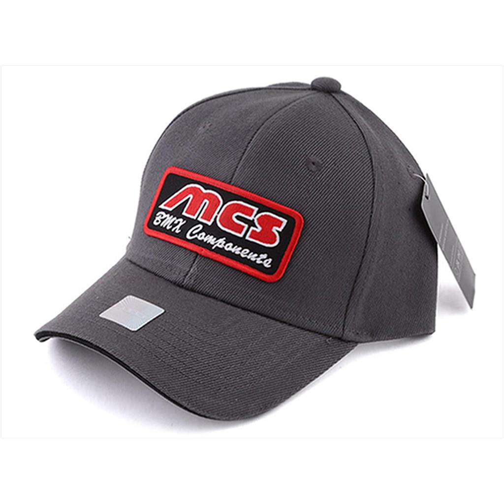 The MCS Logo Cap is a dark gray snap-fit hat made from 100% cotton, featuring a red and white "MCS BMW Components" patch on the front, a side tag, and an adjustable fit for comfortable wear.