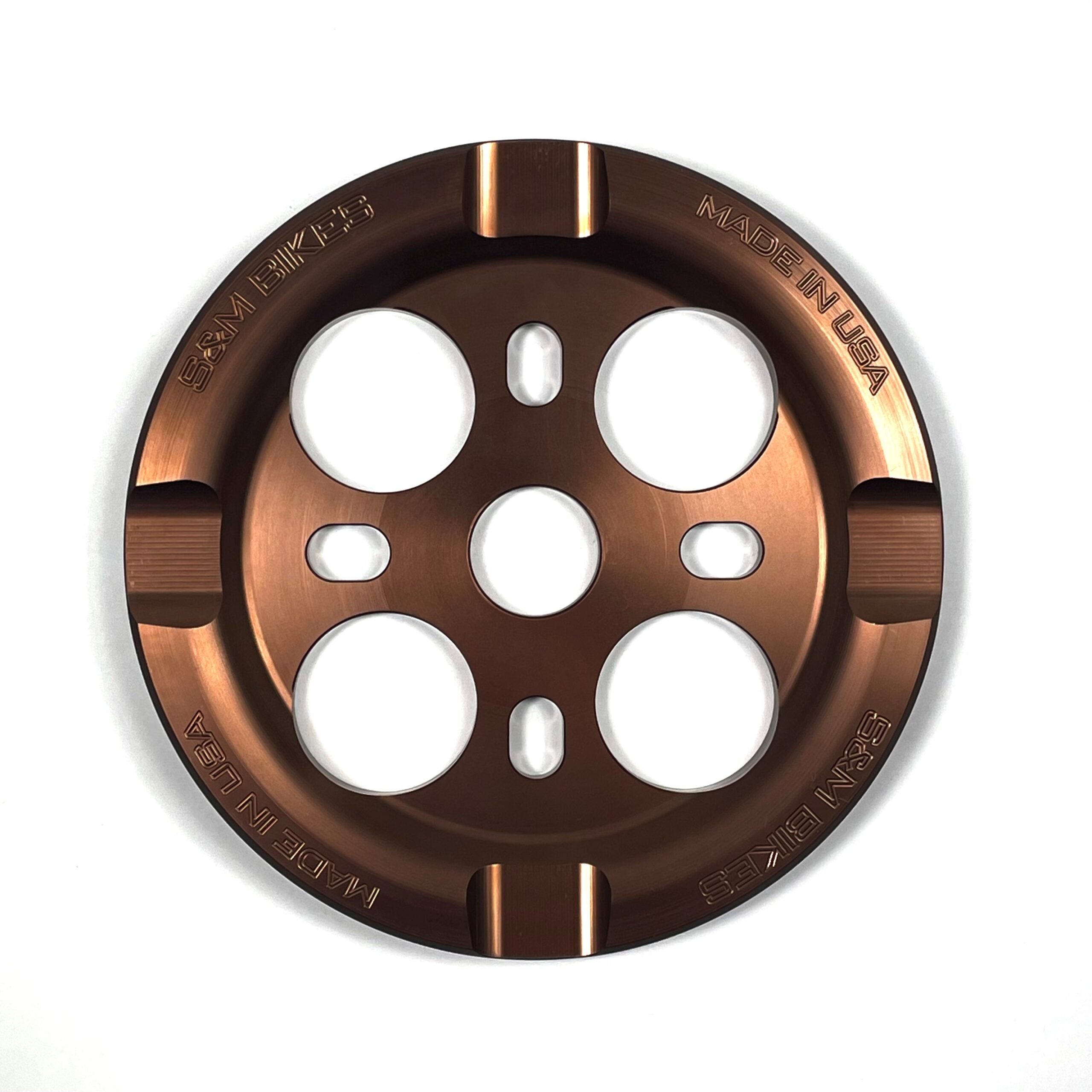 The S&M Mid School Guard Sprocket is a bronze metal bashguard sprocket featuring four large holes and "S&M BIKES" plus "MADE IN USA" engraved along the outer edge.