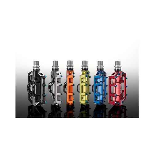 Six vibrant Funn Mamba S SPD Pedals lined up on a reflective surface, each featuring a black base and raised grips, showcasing hues of gray, blue, orange, yellow, green, and red.