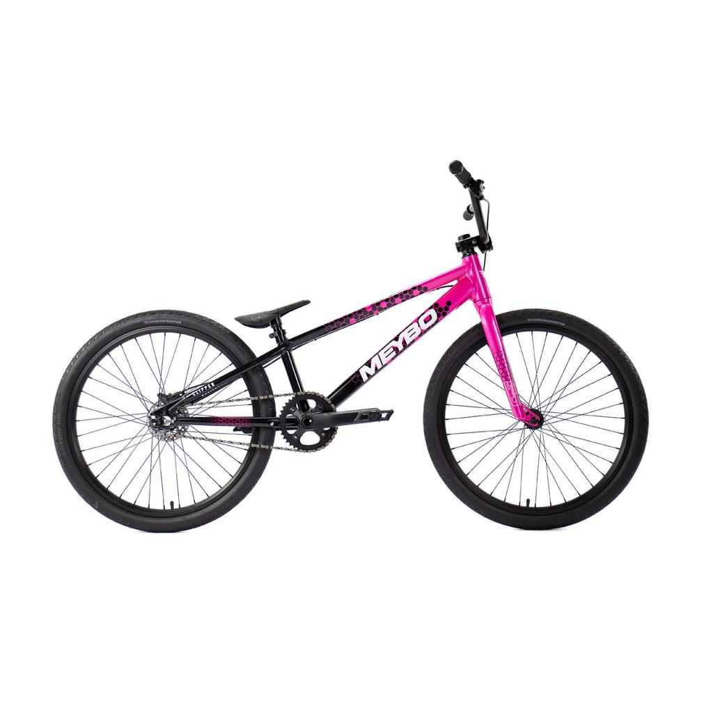 The Meybo 2026 Clipper Pro Cruiser Bike is an entry-level BMX race bike with a black frame, pink accents, thick tires, single gear, and no visible suspension—ideal for beginners. Shown against a white background.