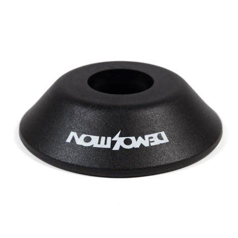 The Demolition Whistler Pro/Rotar Non Drive Side Hub Guard is a black, cone-shaped BMX hub guard with a wide base and central hole, featuring an upside-down white DEMOLITION logo for superior front hub protection during grinds.