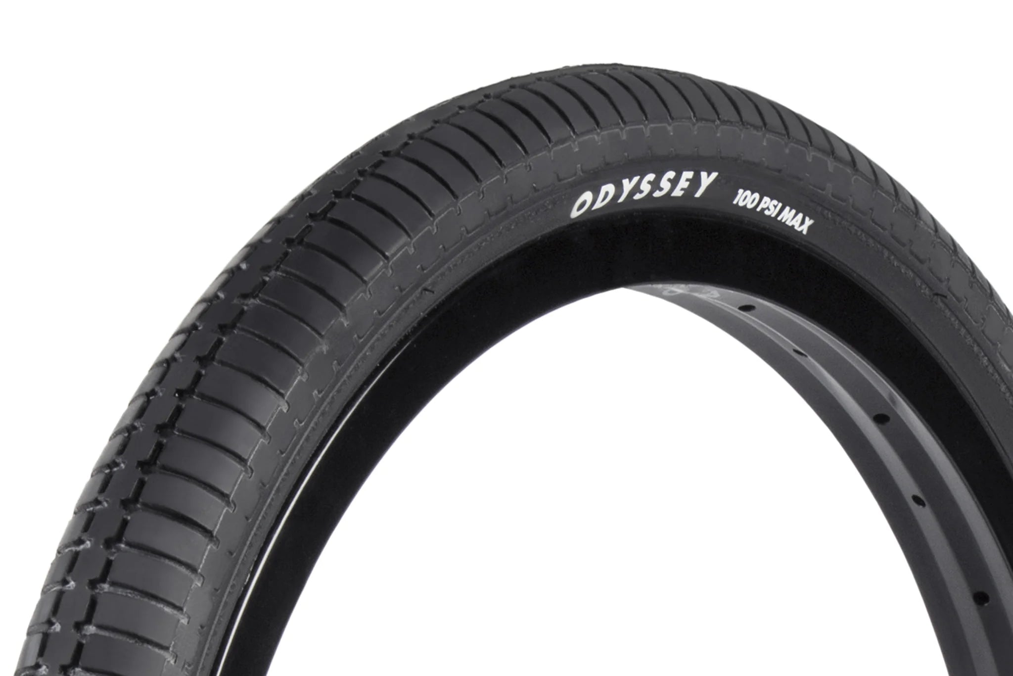 Close-up of a black Odyssey Frequency G Tyre (Each) BMX street tire with the brand name “Odyssey” and “100 PSI Max” printed in white on the sidewall. The tread pattern highlights the special compound tread unique to the Odyssey Frequency G Tyre.