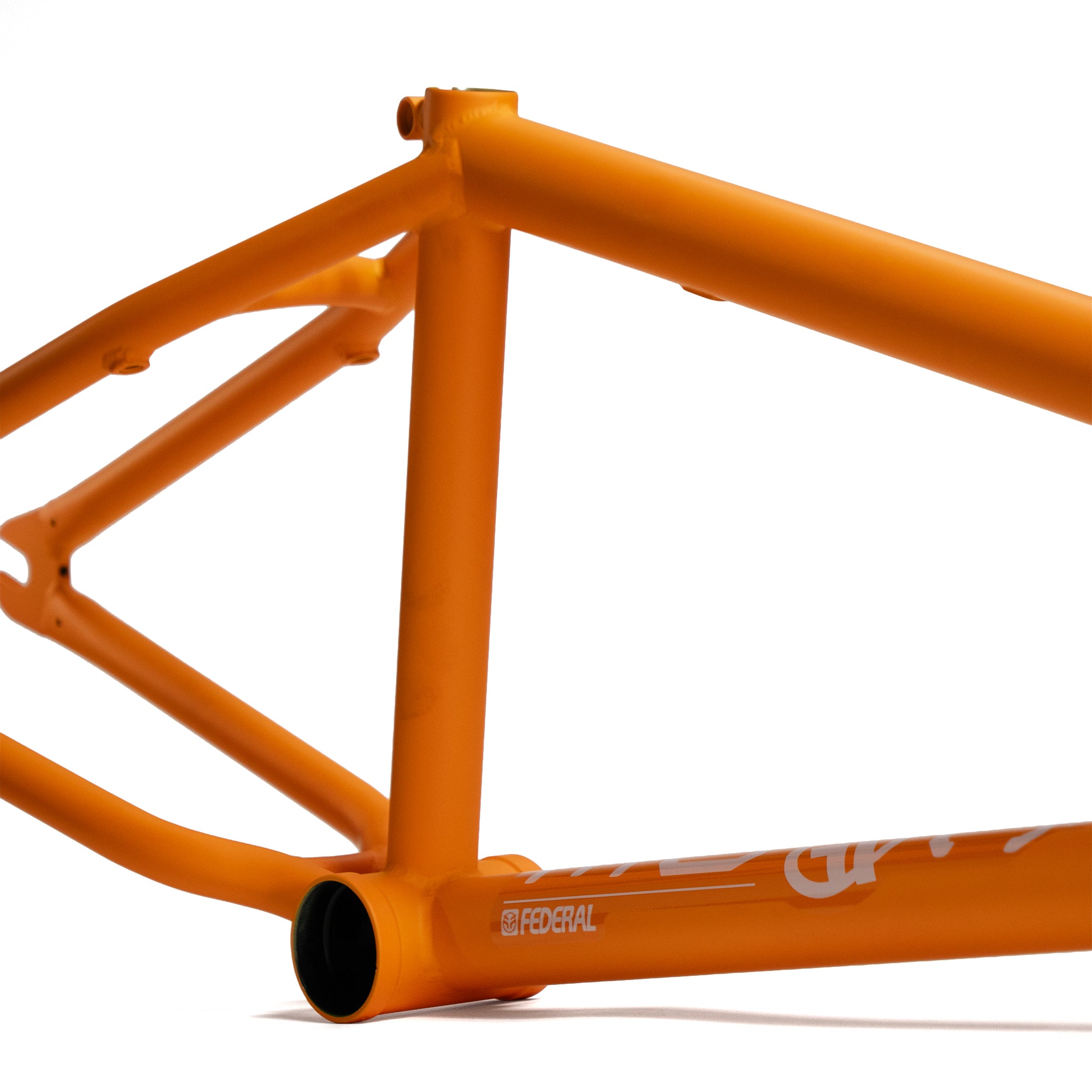 Close-up of the orange Federal Code Frame BMX, showcasing its bottom bracket, seat tube, and chainstay—ideal for street riders. The "Federal" branding stands out boldly on the frame.