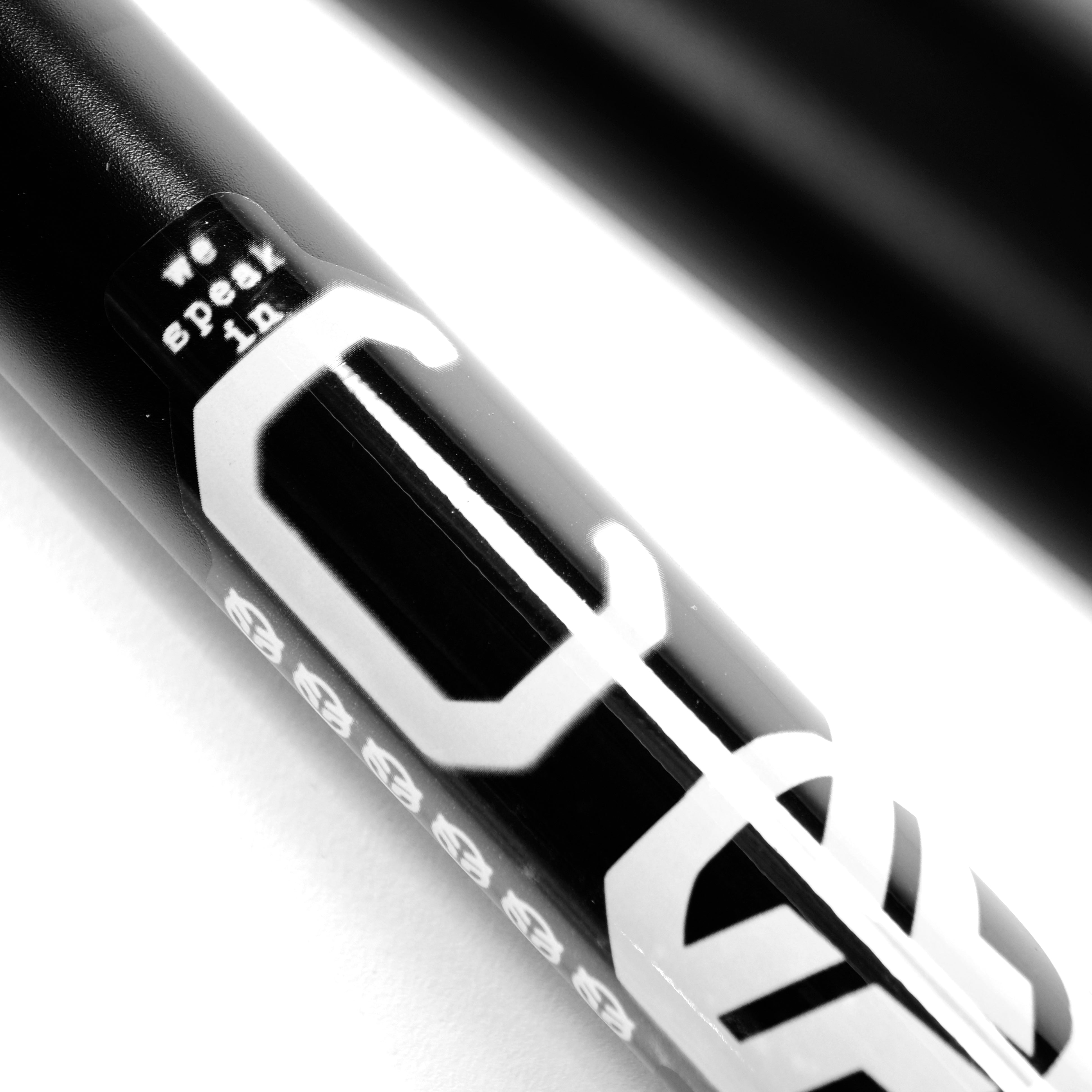 Close-up of a black Federal Code Frame BMX with white "we speak in" text and part of a large stylized letter, ideal for street riders, on a white background.