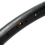 Close-up of the ION BMX C20 Carbon Fiber 20 Inch Braking Rim, made from Toray T800 carbon fiber, with multiple spoke holes and a subtle logo on its sleek black surface.