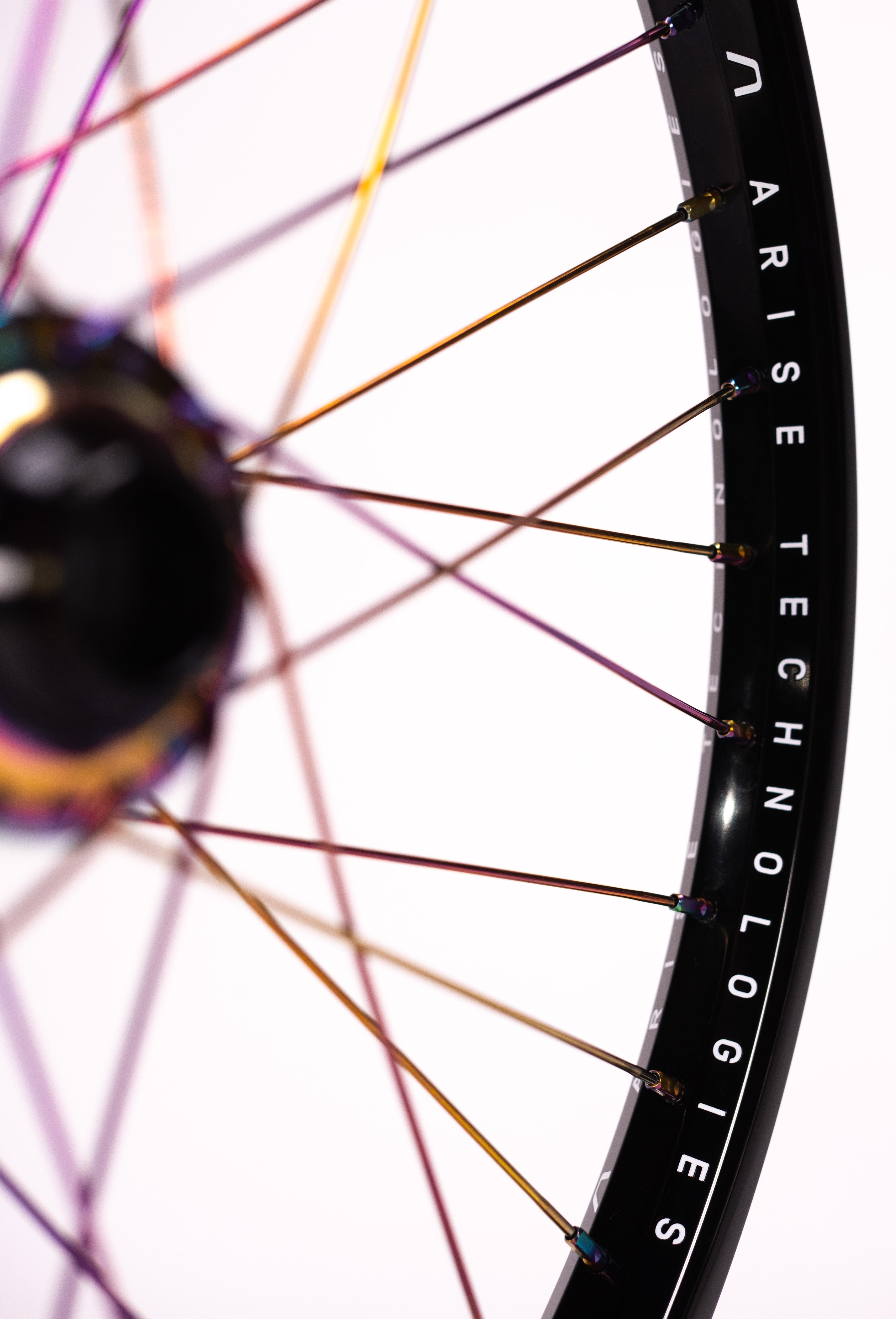 Close-up of the Arise Echo Oilslick Pro 20 Inch Wheelset showcasing iridescent spokes and tubeless-ready black rims with "ARISE TECHNOLOGIES" branding against a white background, designed for optimal engagement drive performance.