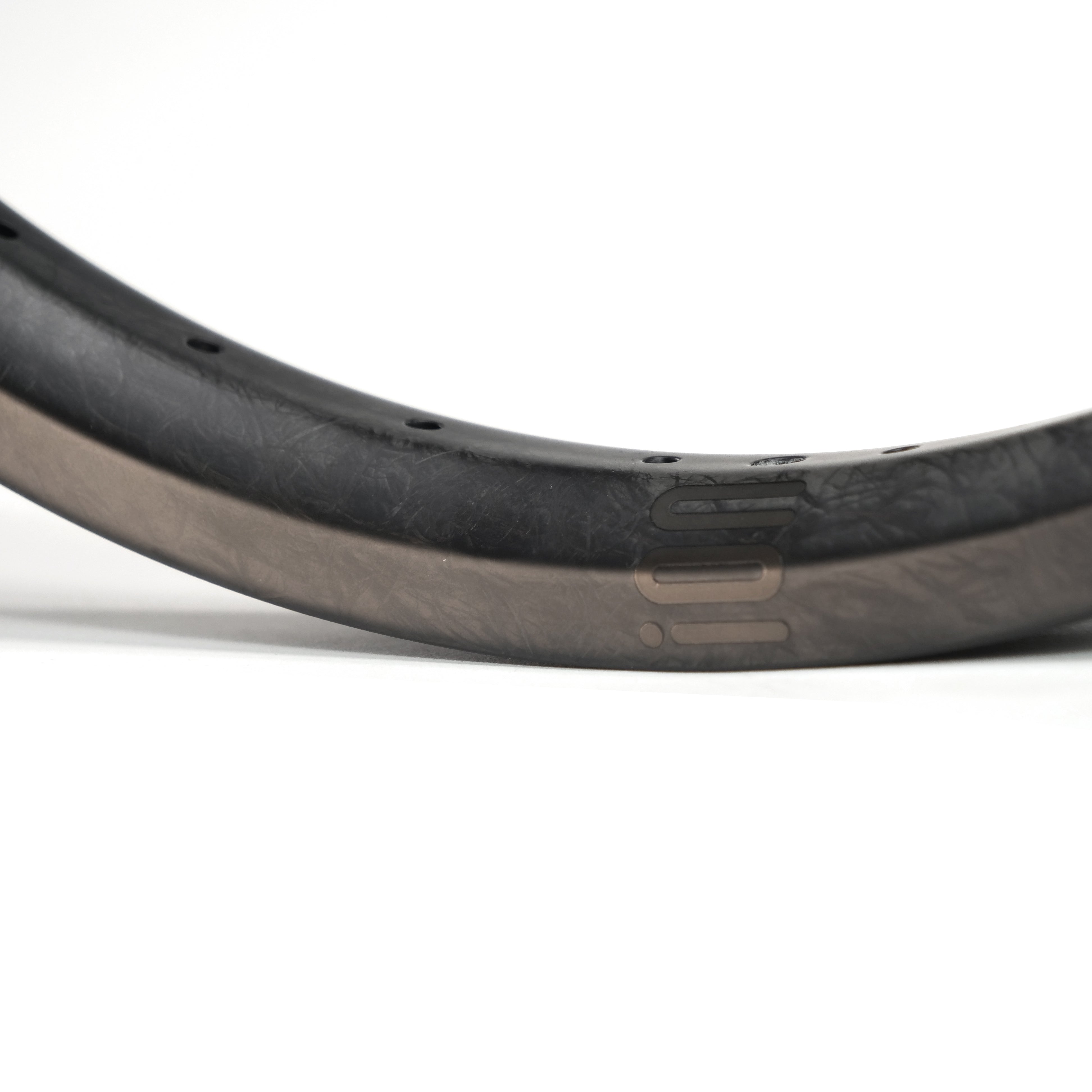 Close-up of the ION BMX C20 Carbon Fiber 20 Inch Brakeless Rim with a matte finish, subtle logo, and evenly spaced spoke holes—ideal for riders seeking high-performance BMX carbon rims.