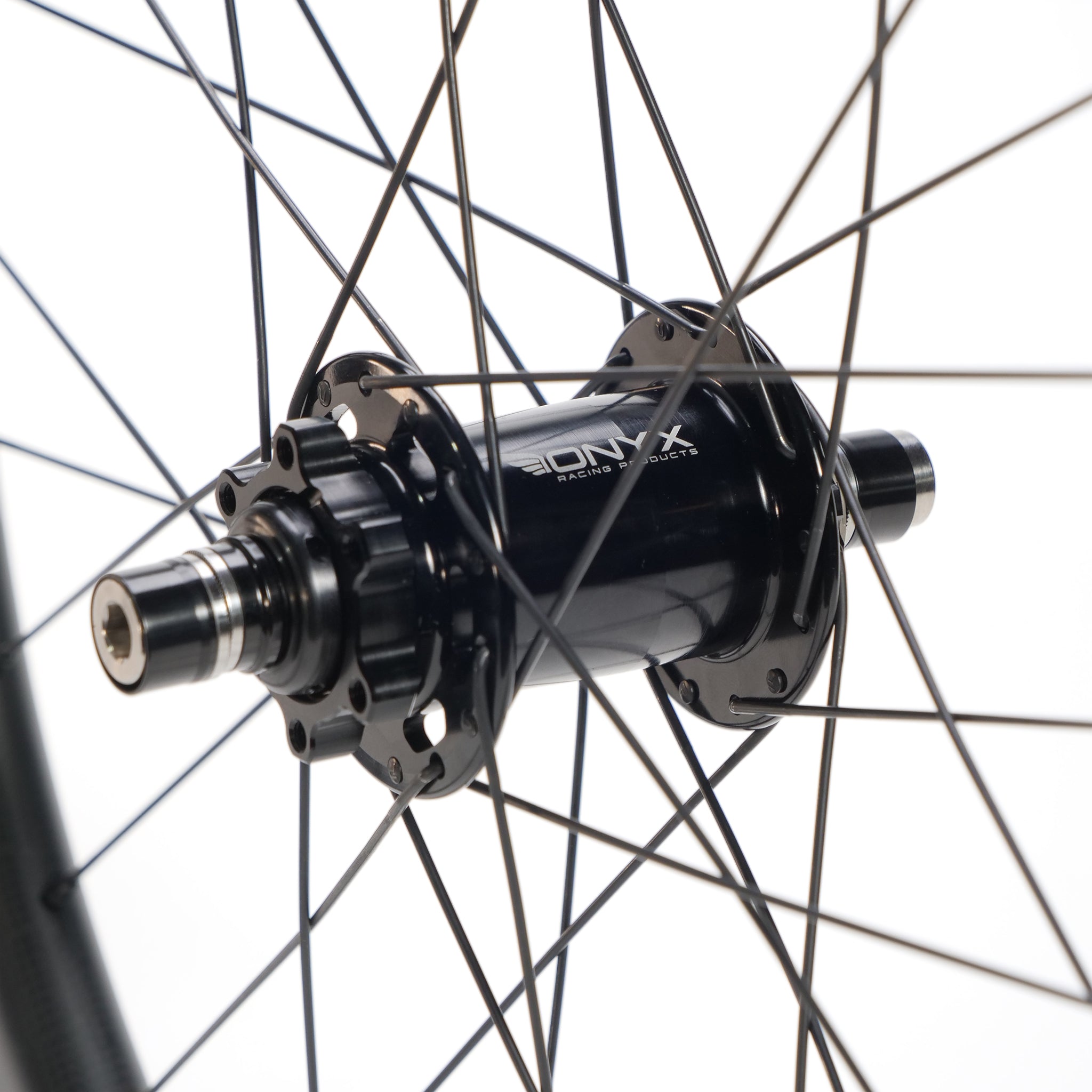 Close-up of a black Onyx bicycle hub with silver spokes, mounted on a Spectre X Onyx 451 Disc Wheel Set alloy rim against a white background.