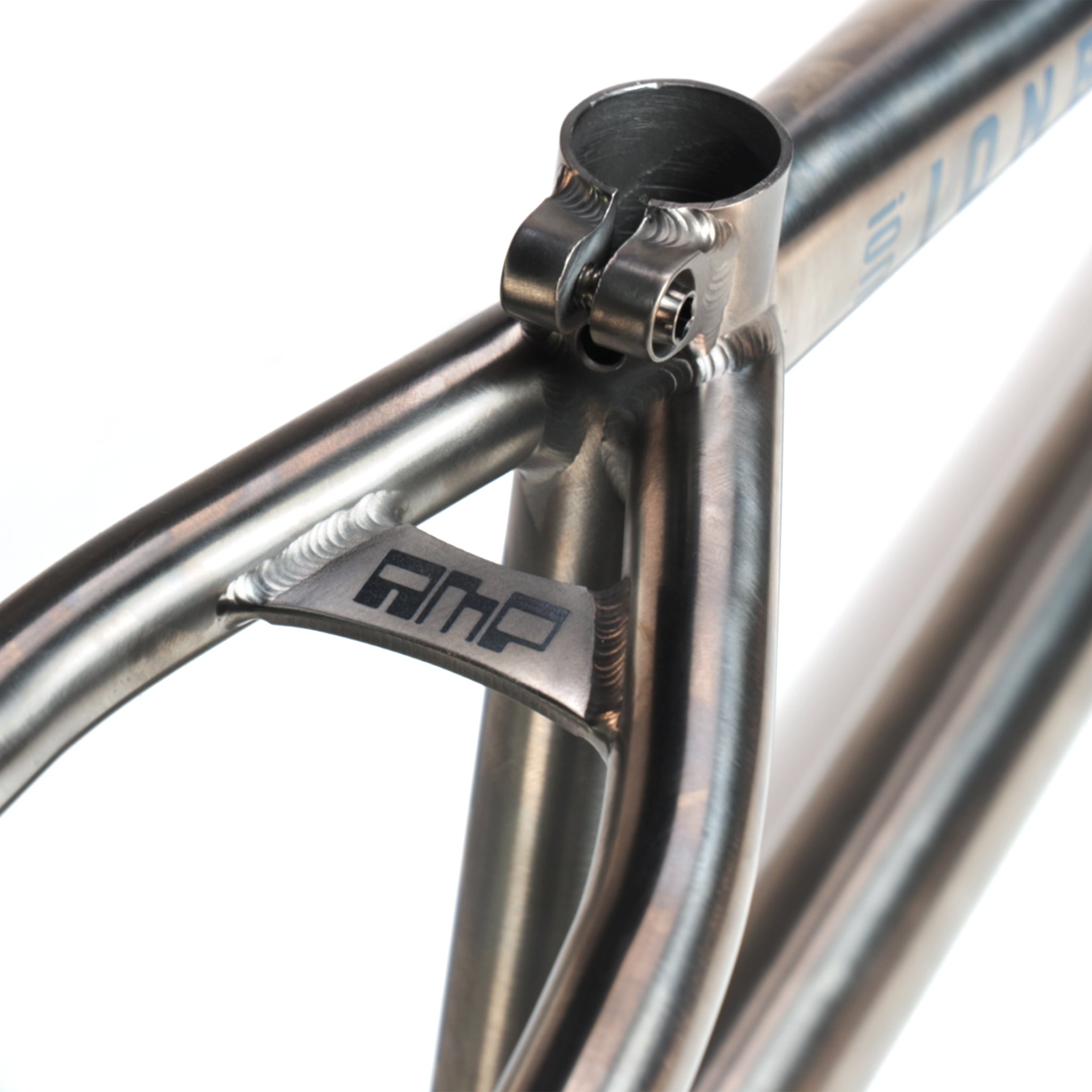 Close-up of the ION BMX AMP20 Titanium 20 Inch Frame highlights the seat clamp area with detailed welds and a small "AMP" logo plate near the seat stays—crafted from aerospace-grade titanium for strength and durability.