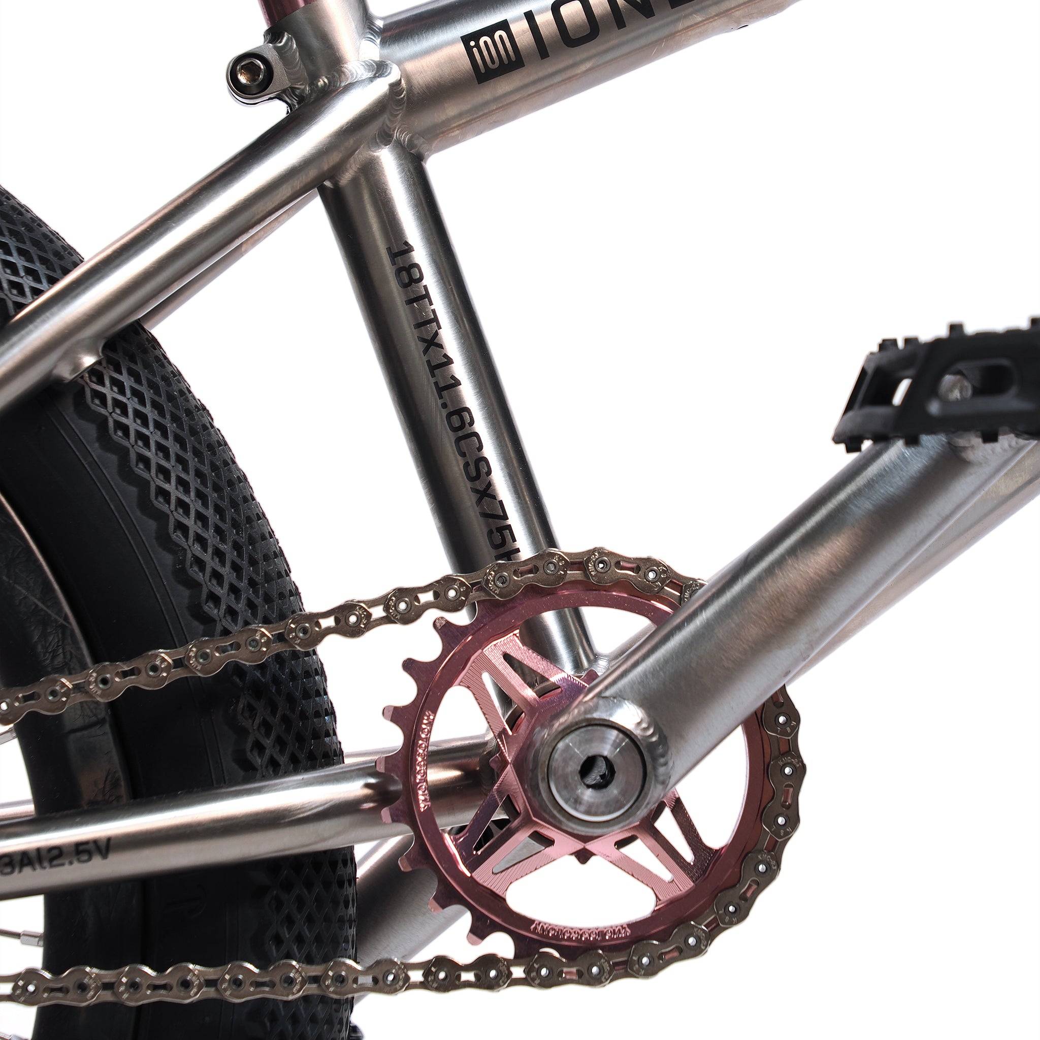 Close-up of the ION BMX Ti18 Custom Titanium 18 Inch Bike's crankset, chainring, pedals, showing its sleek titanium frame tubing, black tire, and chain.