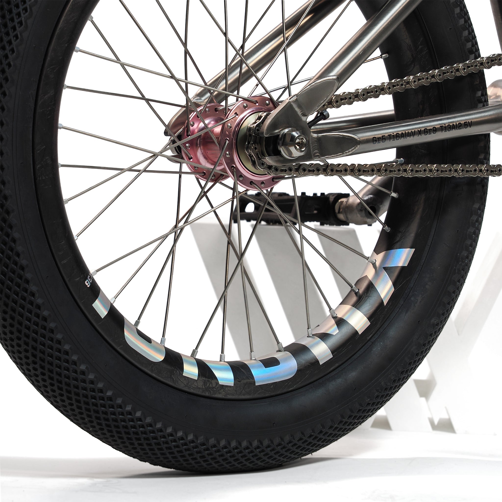 Close-up of the rear wheel on an ION BMX Ti18 Custom Titanium 18 Inch Bike, showing the tire, spokes, chain, and rear hub. "TURBINE" appears on the rim, emphasizing this bike's lightweight freestyle performance.