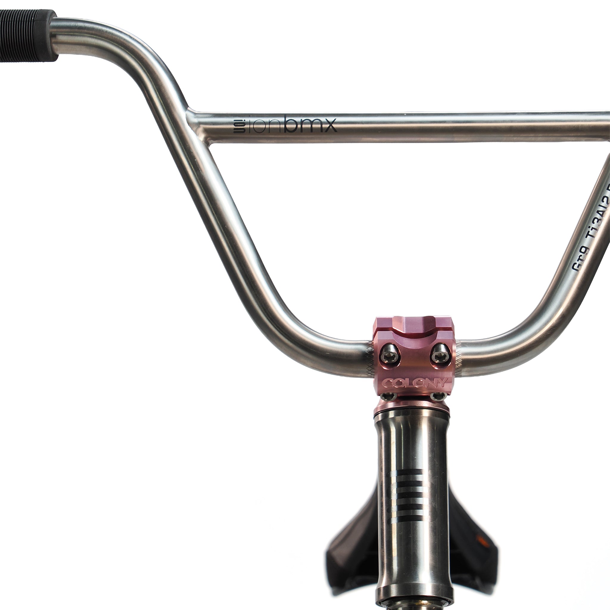 Close-up of the ION BMX Ti18 Custom Titanium 18 Inch Bike's chrome handlebars with a pink stem clamp, set against a white background.
