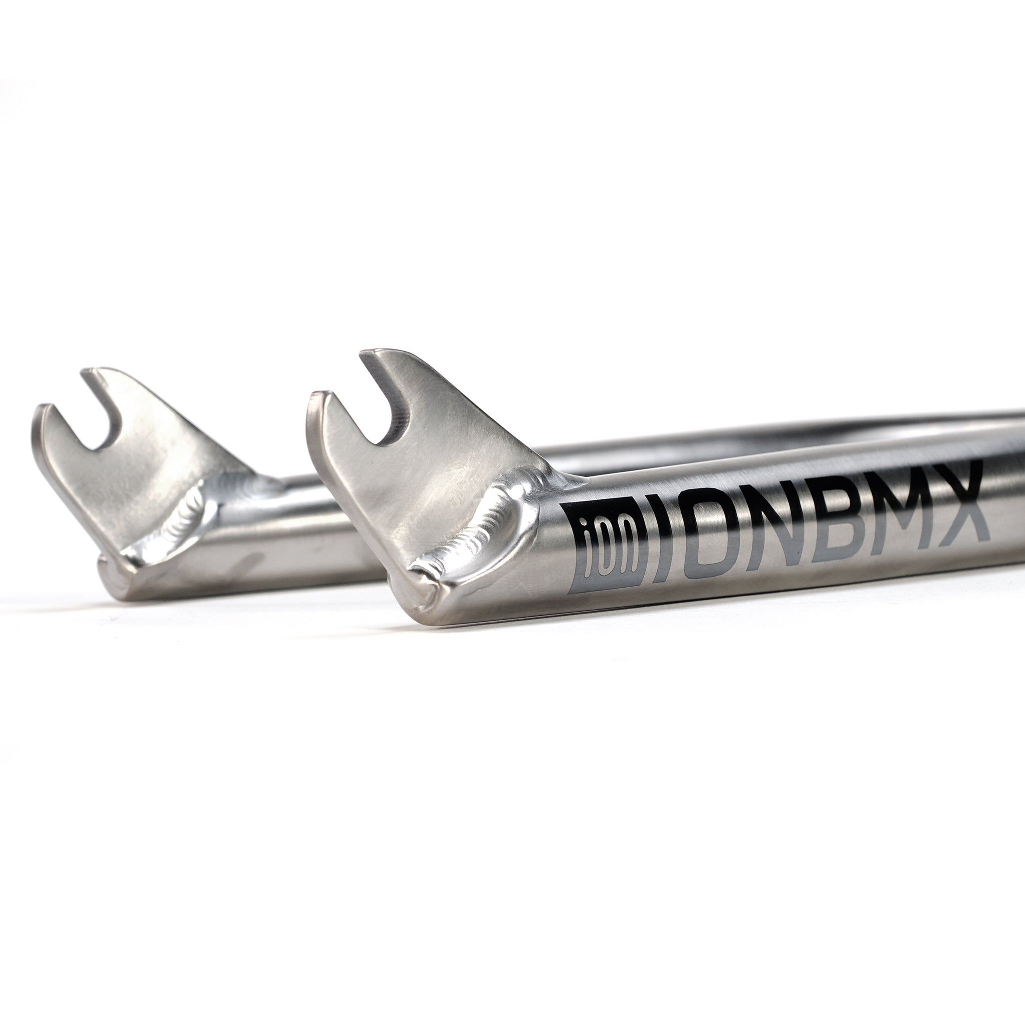 Close-up of two metallic ION BMX Ti16 Titanium 16 Inch Forks dropouts with visible welds and branding on the tubes.