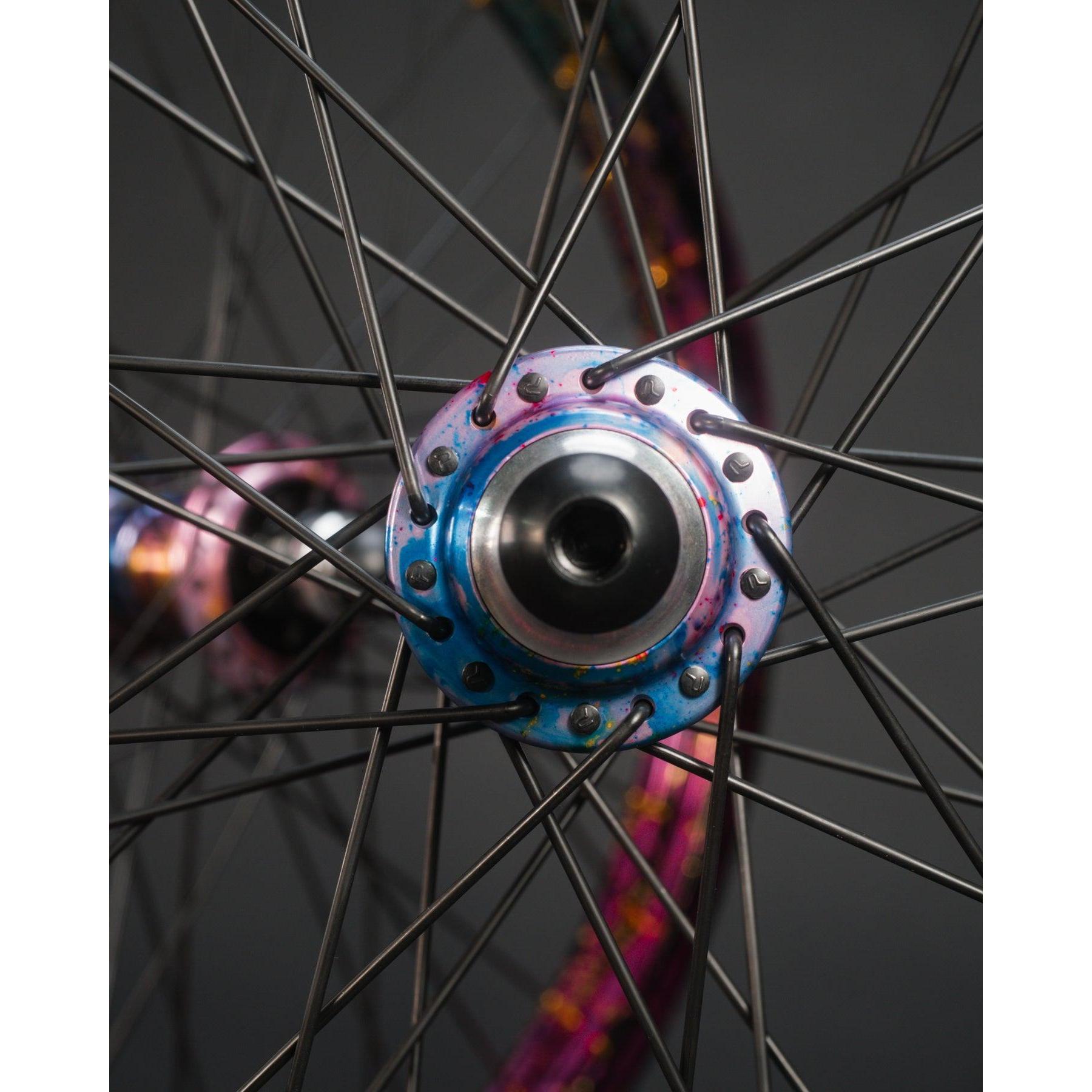 Close-up of the limited edition Profile x Odyssey Near Earth Objects Wheel Set, featuring silver spokes in a radial pattern and vibrant accents, set against a dark background.