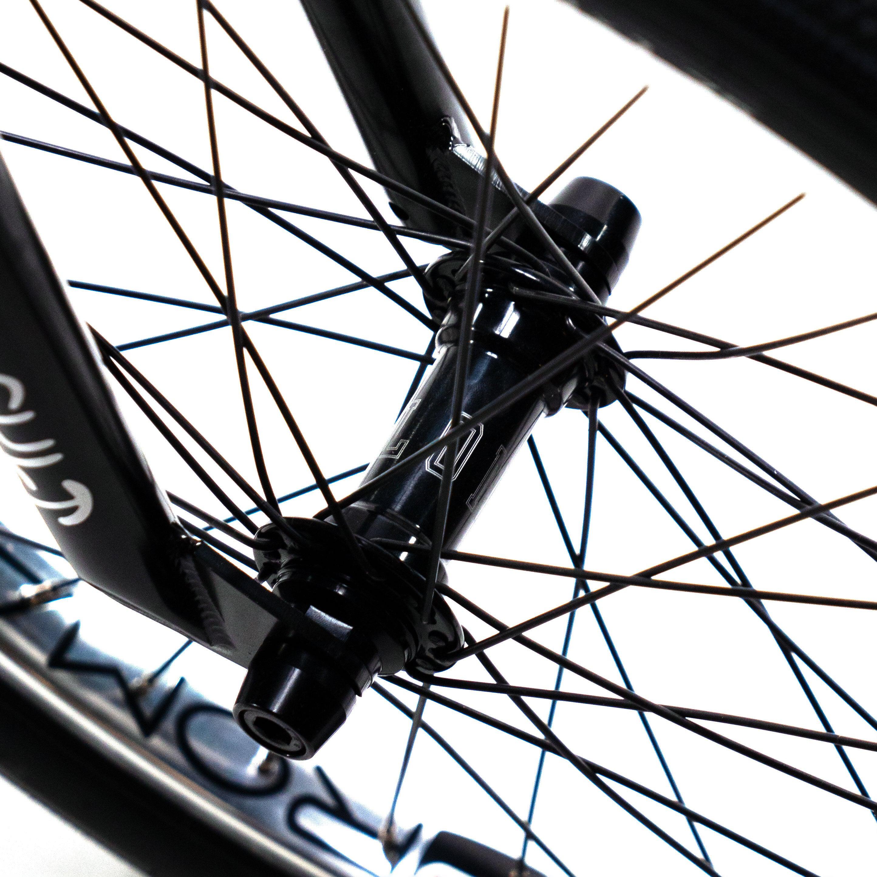 A close up of a black Cult Vick Behm Custom Race Bike wheel featuring Spectre NME carbon rims.