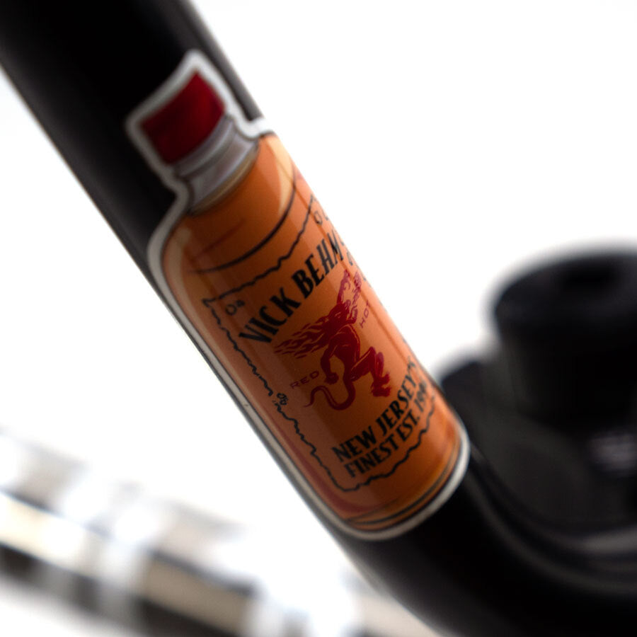 A close up of a Cult Vick Behm Custom Race Bike with a bottle mounted on the stylish handlebar.