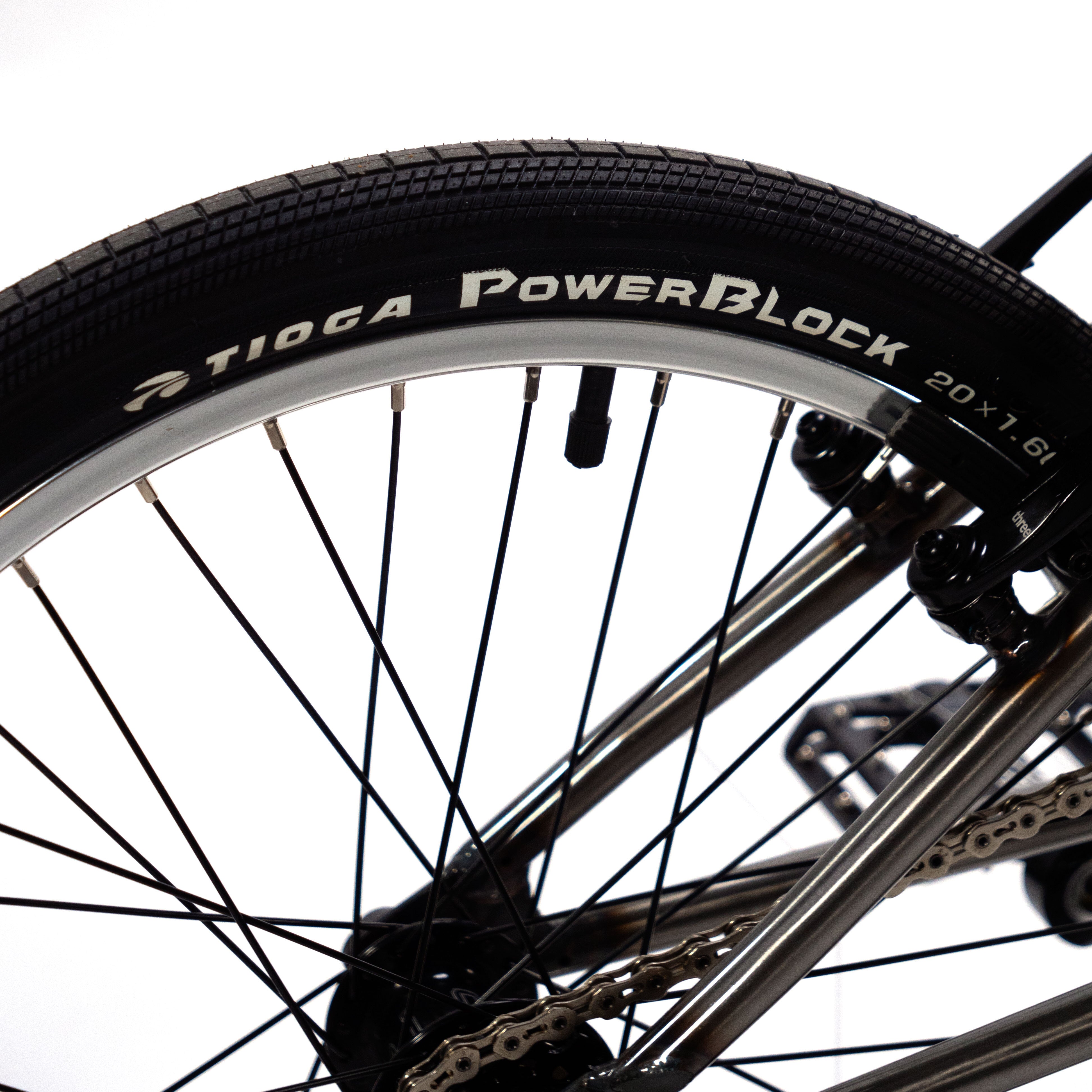 A close up of a Cult Vick Behm Custom Race Bike tire with the word powerblock on it, featuring Spectre NME carbon rims.