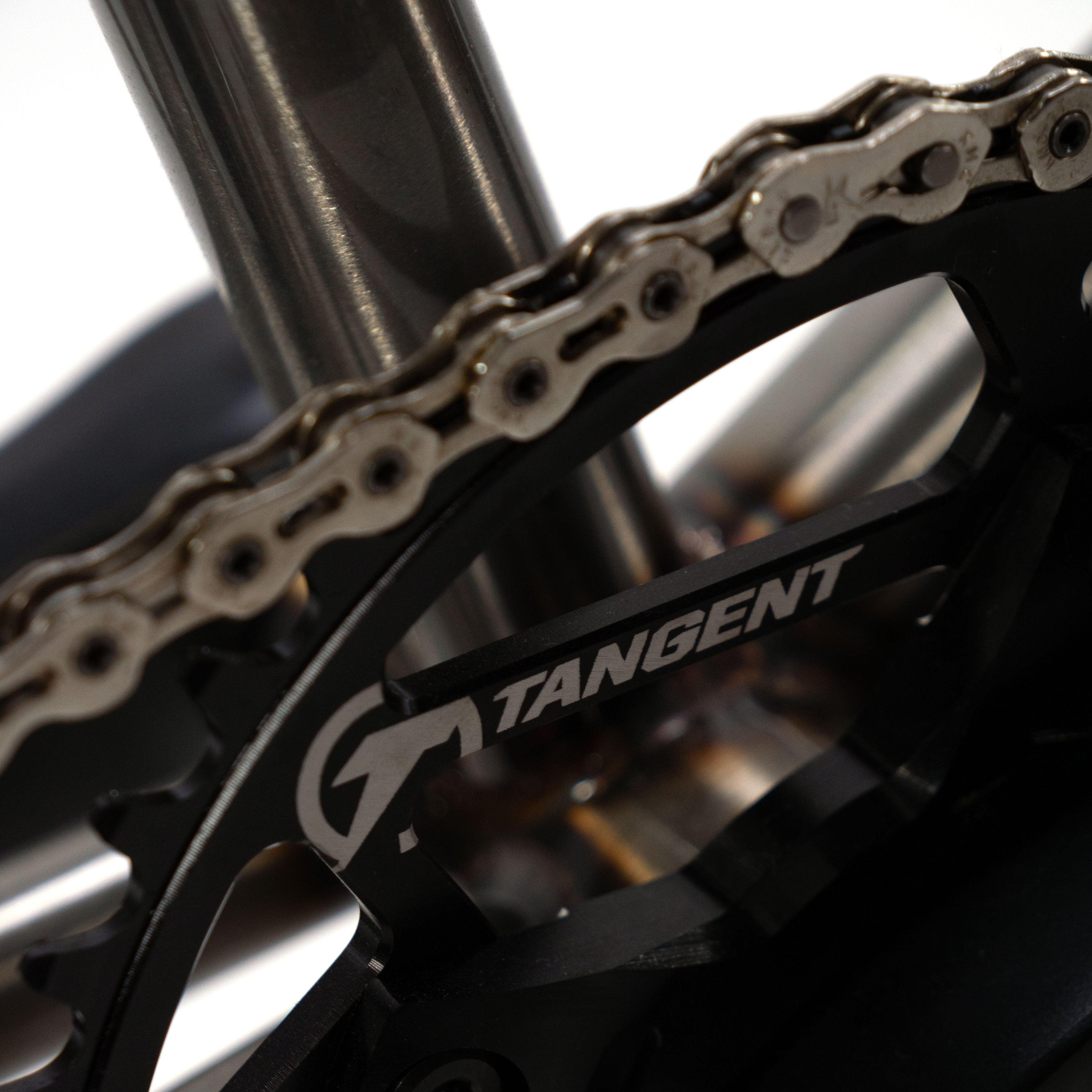 A close up of a Cult Vick Behm Custom Race Bike chain with the word tangent on it.