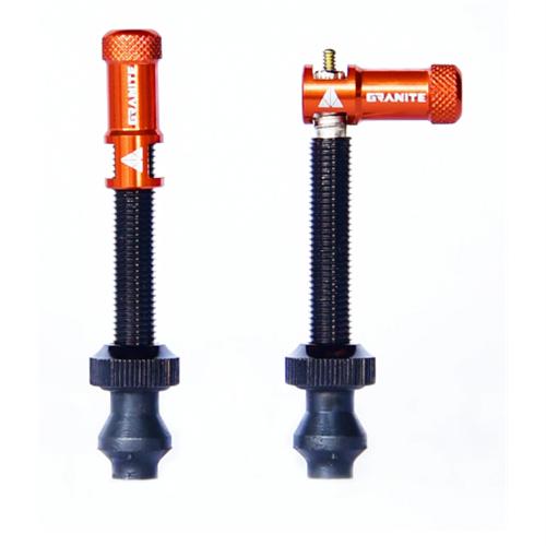 Two Granite Juicy CNC Presta valve caps with built-in valve core removers are shown upright against a white background, one featuring the valve core remover cap and the other adorned with a right-angle adapter—an ideal pairing for efficient bike maintenance.