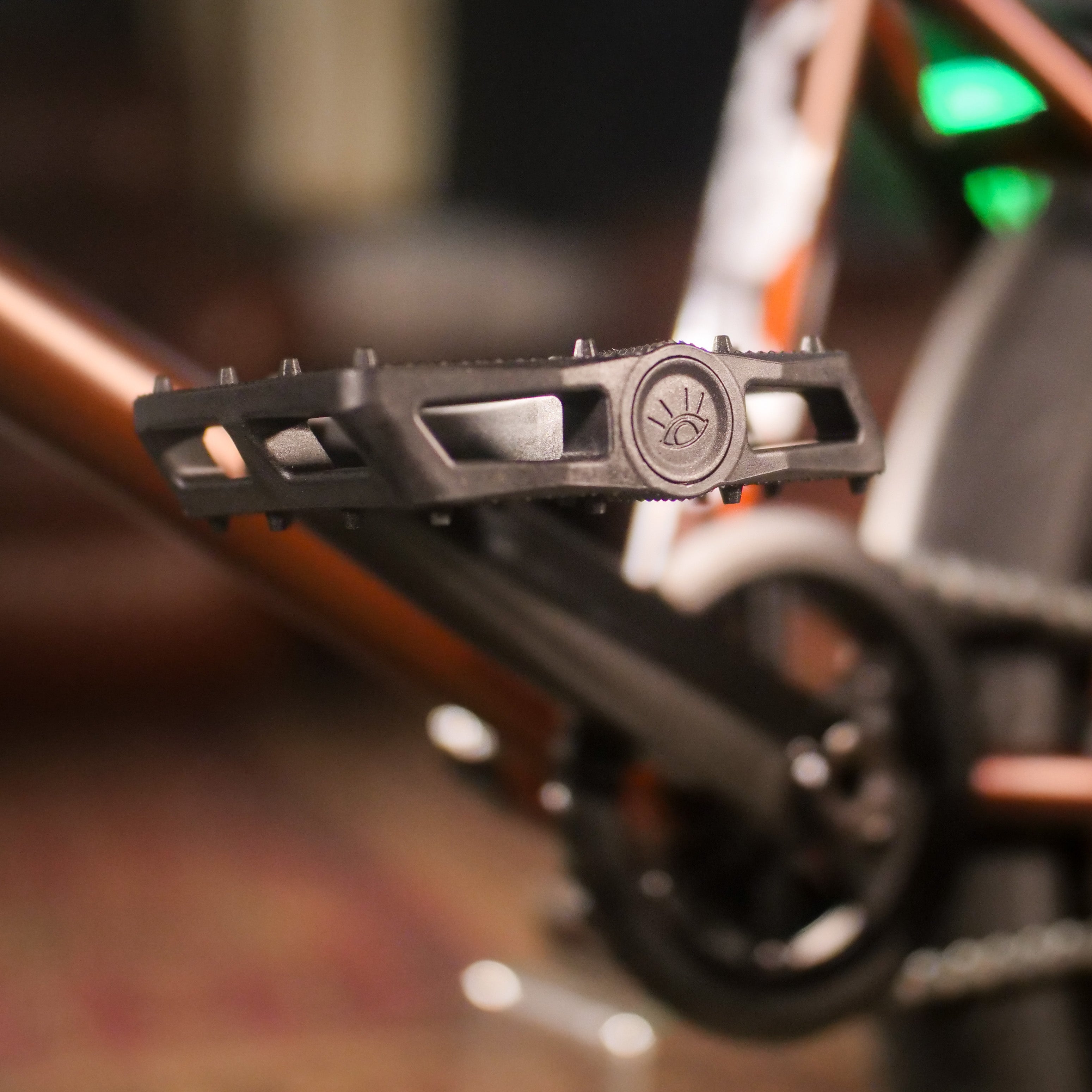 Close-up of a black pedal attached to the crank arm of the Cult Dak X Eclat Custom 'Pat Freyne Signature' BMX, with part of the frame and gear visible in the background.