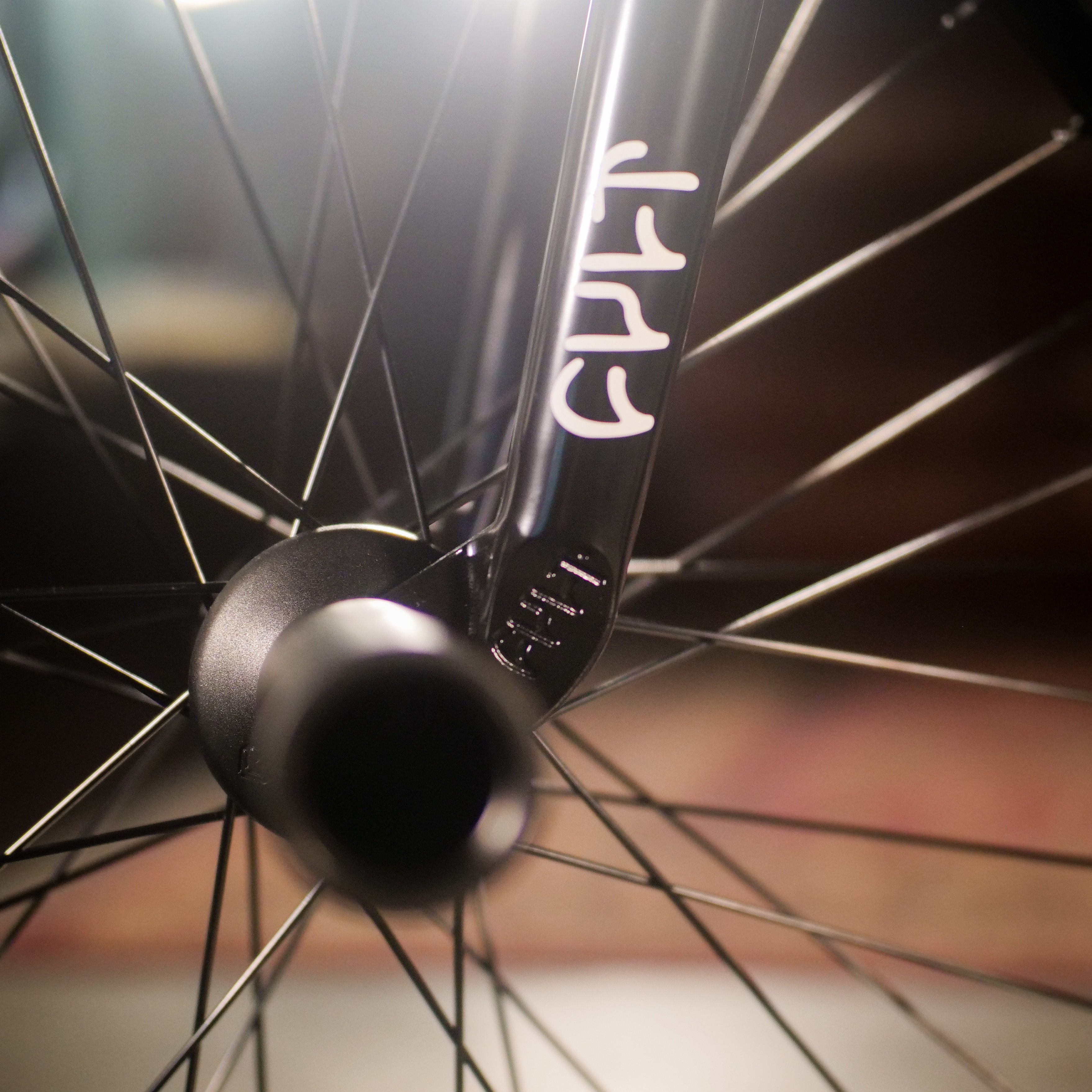Close-up of a BMX wheel highlighting spokes and fork, with white markings on the Cult Dak X Eclat Custom 'Pat Freyne Signature' frame—a top pick among BMX bike parts.
