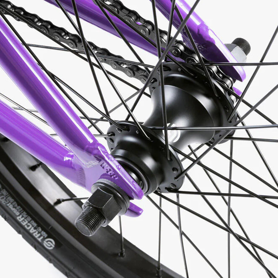 A close up of a purple Wethepeople Nova 20 Inch BMX bike with black spokes.