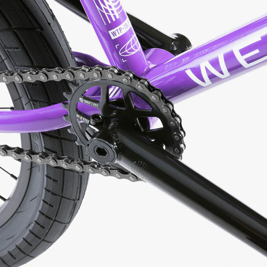 A purple Wethepeople Nova 20 Inch BMX bike with a chain on it.