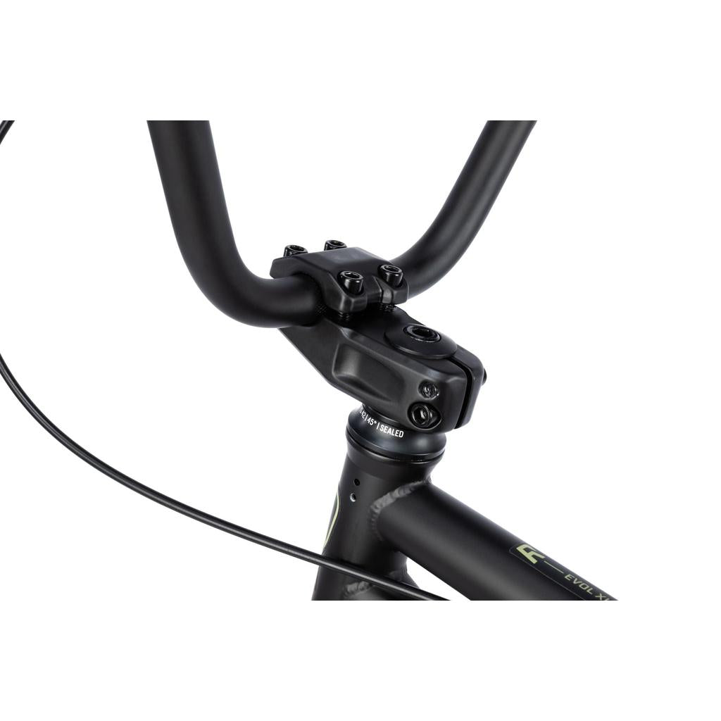 Close-up of the black handlebar, stem, and sealed integrated headset of the Radio Evol XL 20 Inch Bike, showing cable routing and part of the matte-finish frame—ideal for entry-level BMX riders.