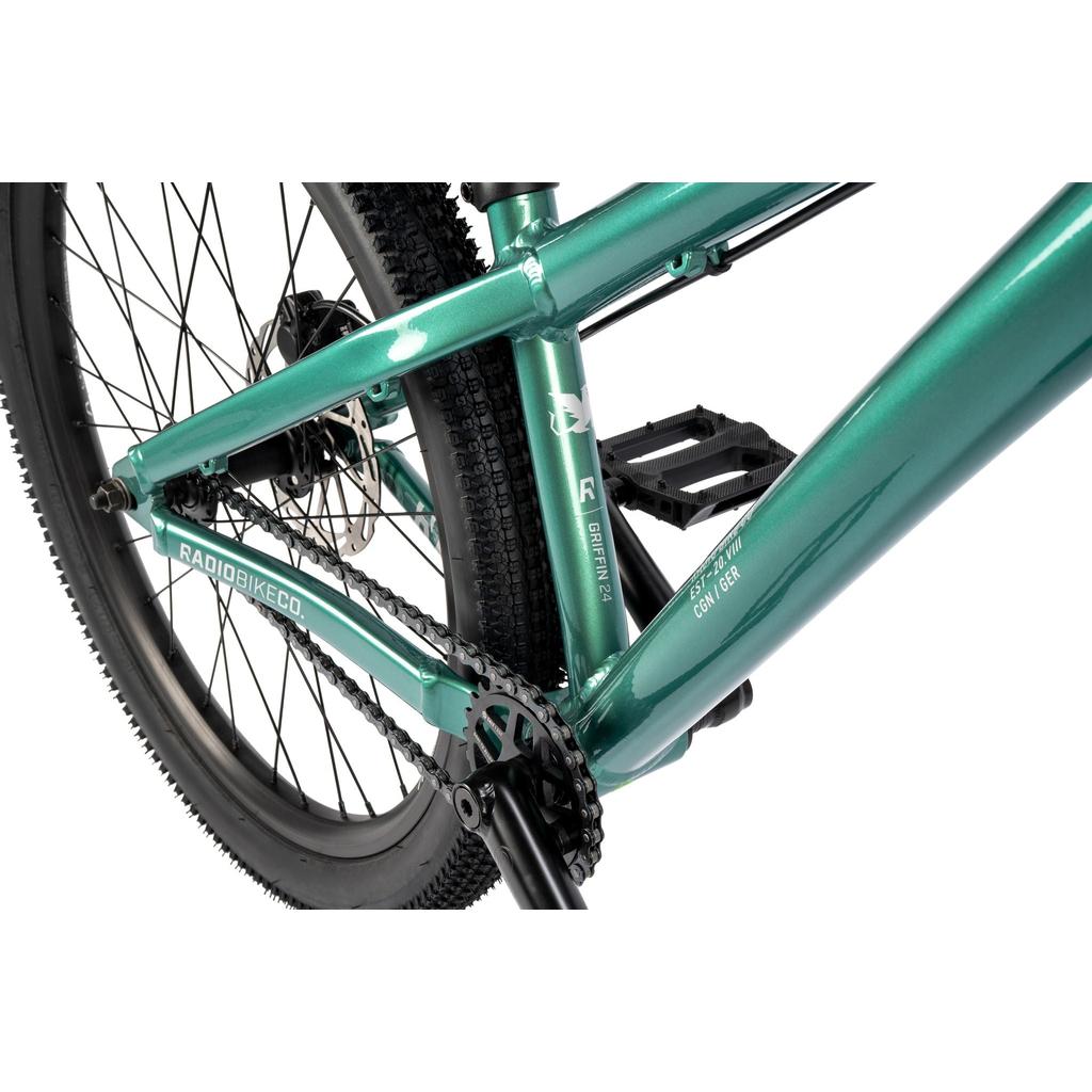 Close-up of the Radio Griffin 24 Inch Dirt Jumper Bike frame in green, highlighting the rear wheel, pedal, chain, and branding—perfect for pumptrack enthusiasts.
