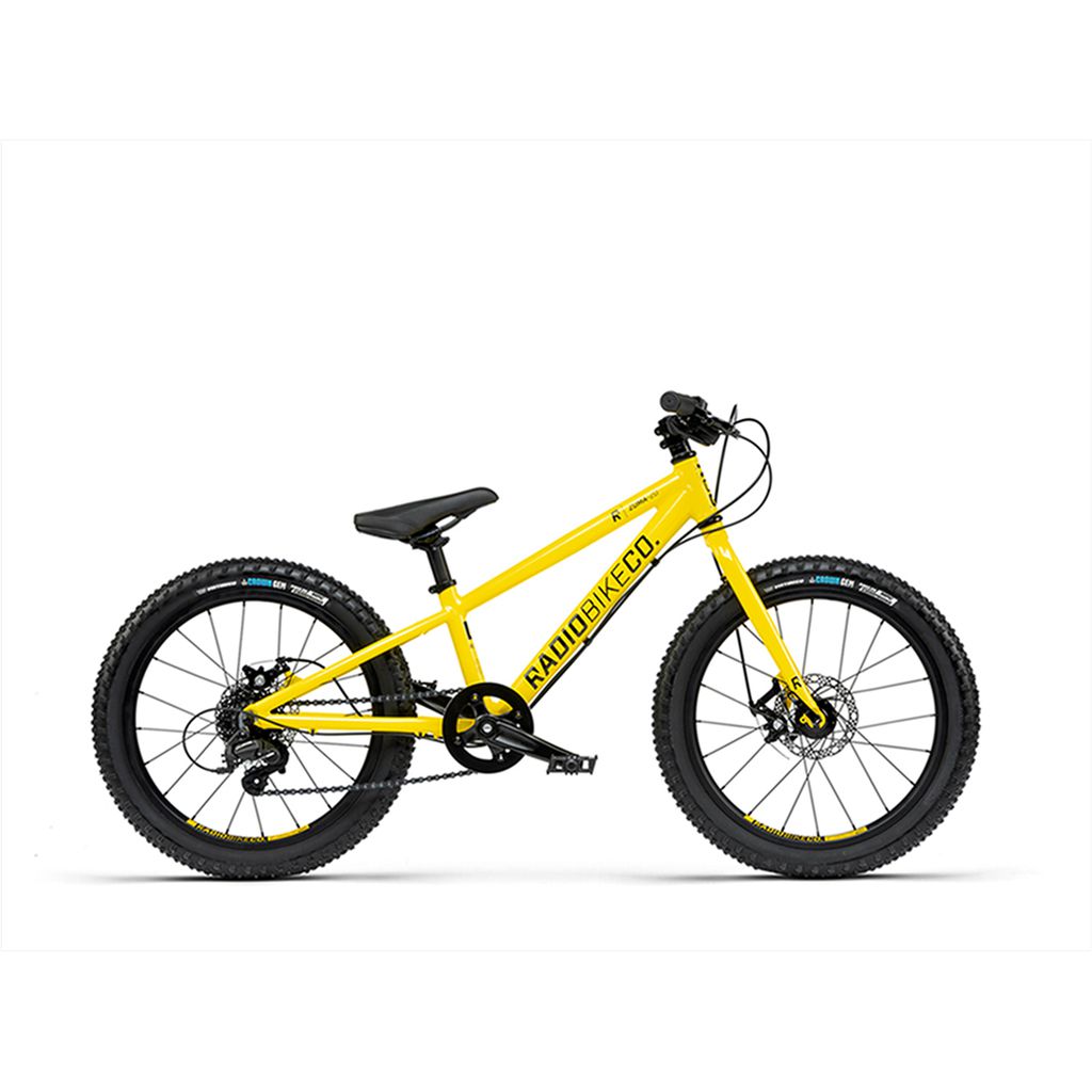 A yellow "Radio 20 Inch Zuma Bike" with black tires and handlebars, featuring a straight top tube and disc brakes. Part of the Zuma range, this child-sized mountain bike boasts a geometrical design for young adventurers.