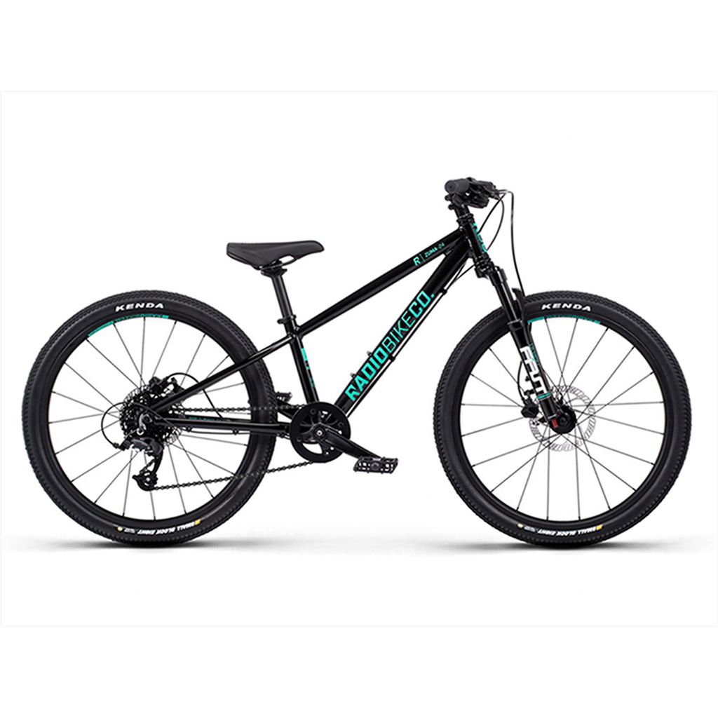 A black mountain bike with "Radio 24 Inch Zuma Sus Bike" branding on the lightweight alloy frame, featuring disc brakes and Kenda tires.