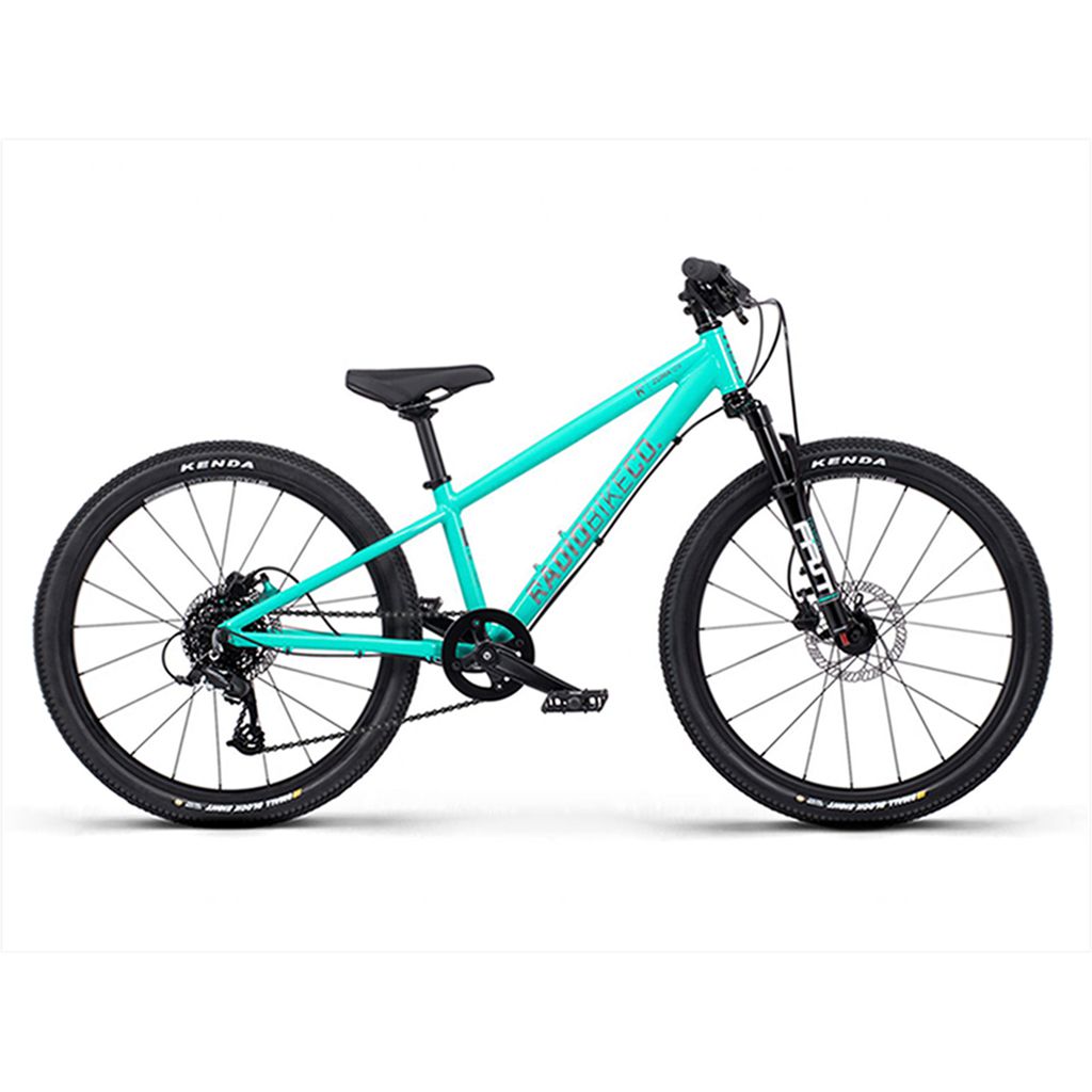 Introducing the Radio 24 Inch Zuma Sus Bike: a kid-sized MTB with a lightweight alloy frame, featuring a teal mountain bike design, black saddle, front suspension fork, and Kenda tires on a white background.