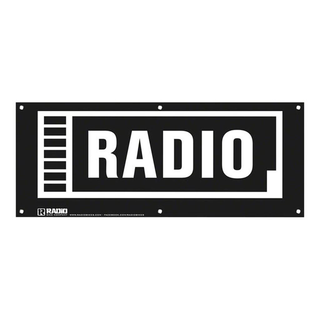 The Radio Contest Banner is a black and white PVC sign featuring "RADIO" in bold capitals, framed with a vertical bar pattern left border. Durable and weather-resistant, it’s perfect for outdoor events.