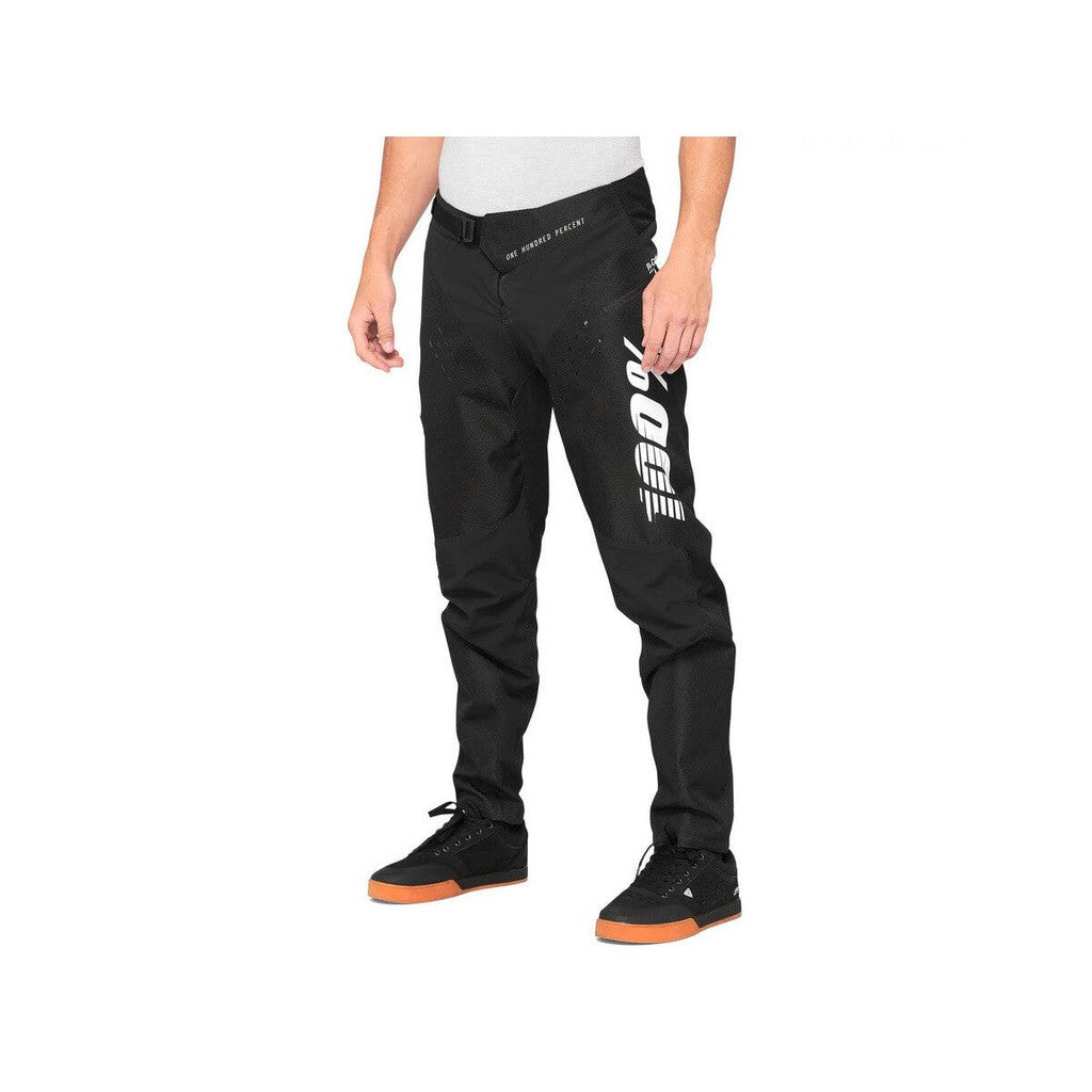 A youth is standing in front of a white background wearing 100% R-Core Youth Race Pants.