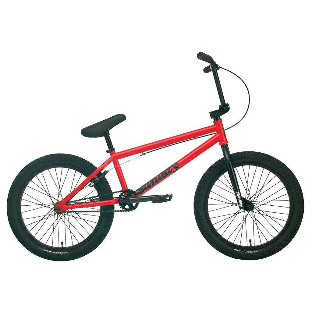 A Sunday Primer 20 Inch Bike in red, featuring a black seat, black handlebars, and black tires, set against a plain white background. This bike boasts pro-level geometry in its simple, minimalist design with no additional accessories.
