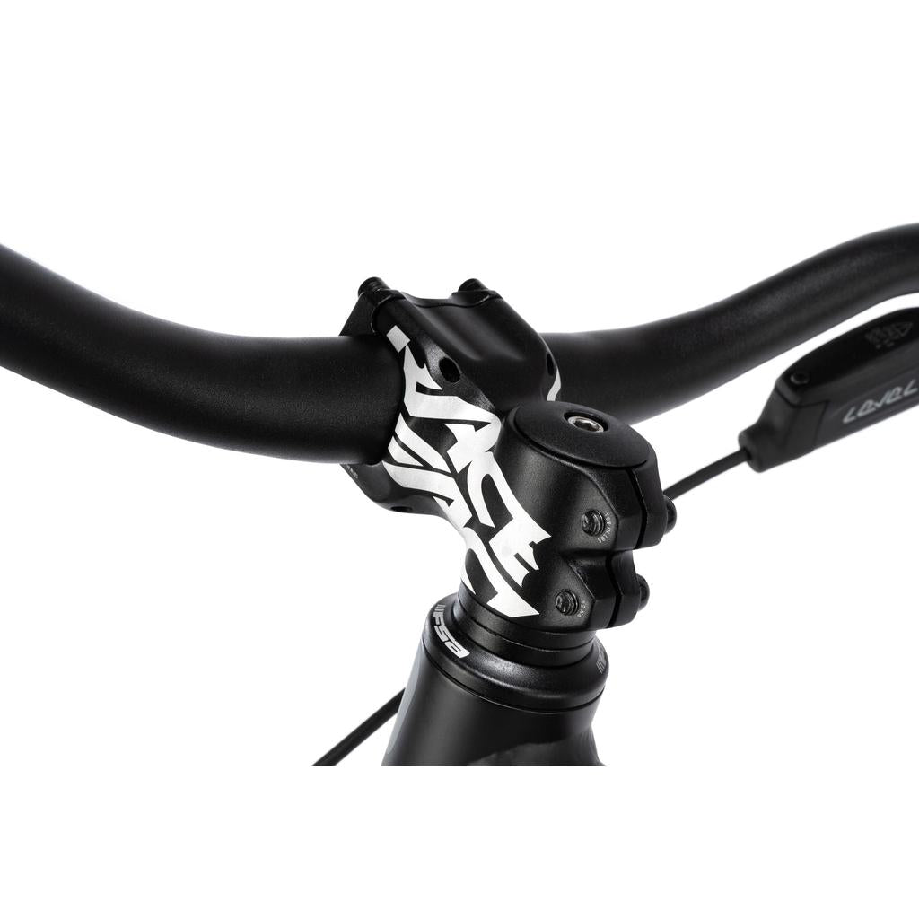 Close-up of the black handlebar and stem with bold white graphics on the Radio 26 Inch Griffin Pro Bike, showing part of the brake lever and cable against a white background.