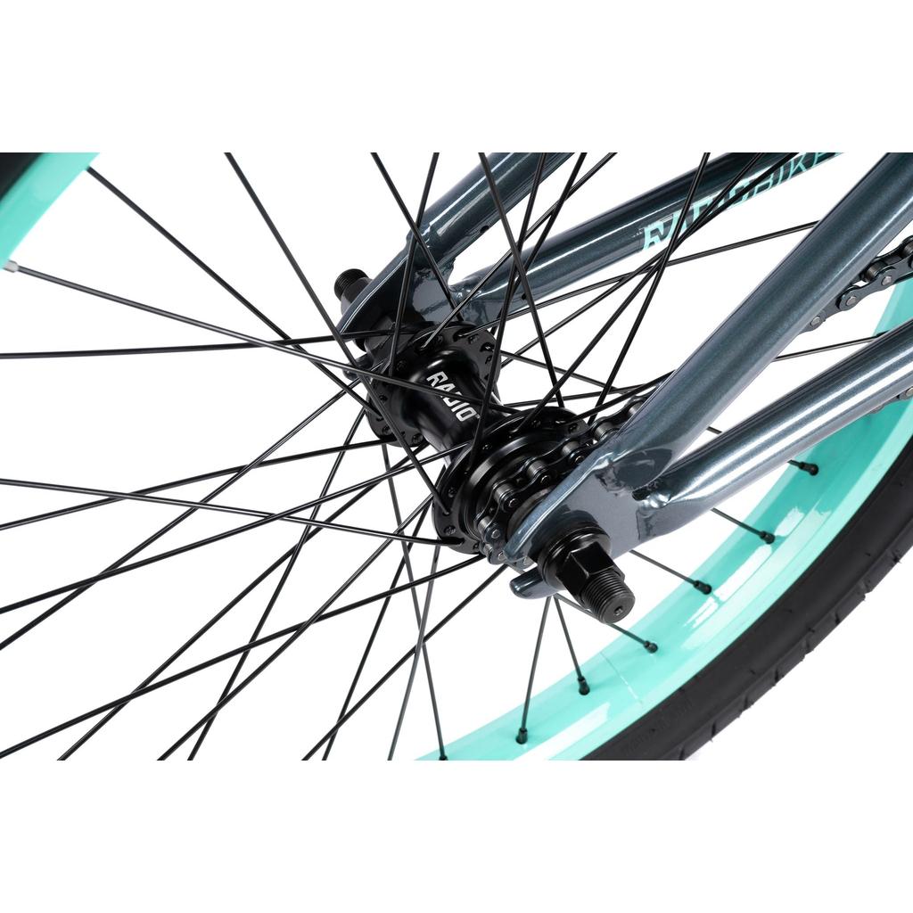 Close-up of the rear wheel on a Radio Saiko 20 Inch Bike, featuring the hub, spokes, axle, and a mint green and black Salt Tracer Tyre.