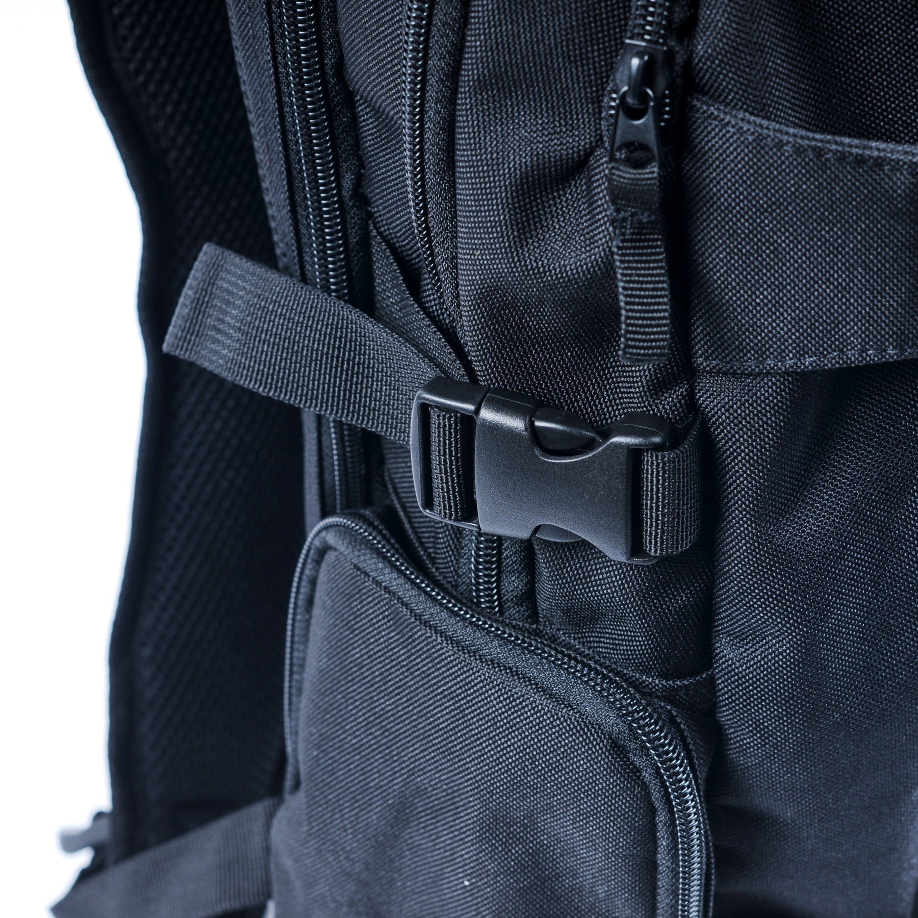 Close-up of the United Dayward Backpack in black, showcasing its plastic buckle, zippers, straps, and textured fabric detail, plus skateboard carry straps for extra functionality.