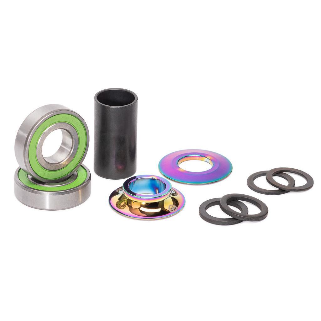 The Salt Plus Echo Mid Bottom Bracket includes sealed bearings, a cylindrical sleeve, washers, spacers, and two rainbow-colored metal rings for Spanish BB frames, all arranged on a white background.