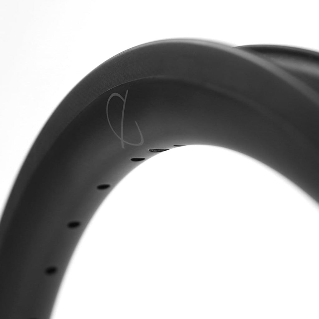 A close up of a reliable black Spectre Carbon Fibre 451x23mm Braking Rim with warranty.