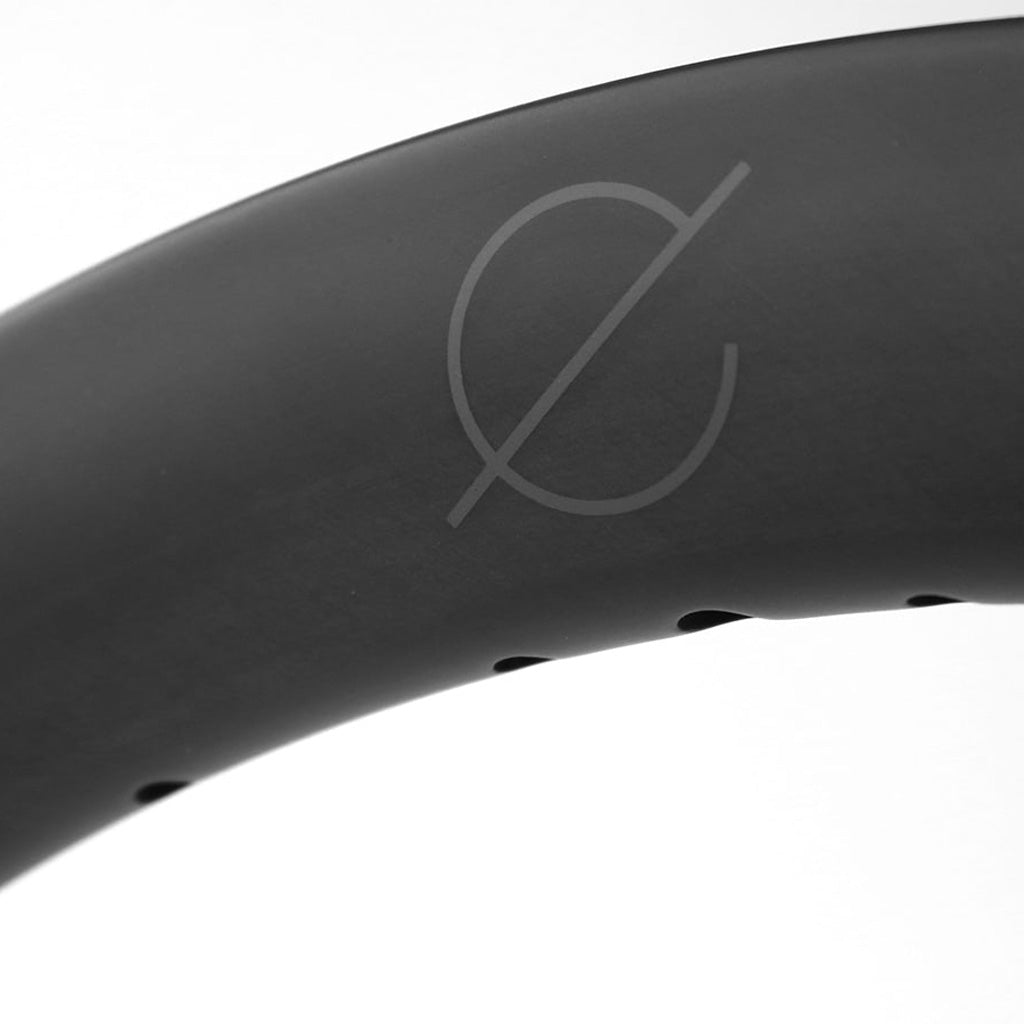 A close up of a black Spectre Carbon Fibre 451x23mm Braking Rim tire, known for its reliability and covered by warranty.