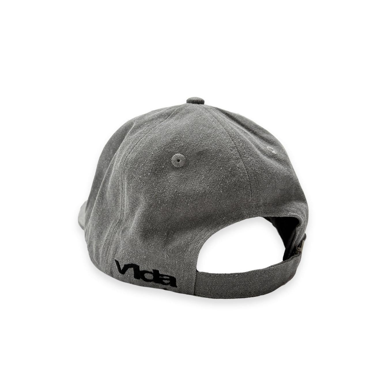 The V1da Shoreline Cap is a gray strapback made from 100% cotton, seen from the back and adorned with black embroidered "vida" near the edge.