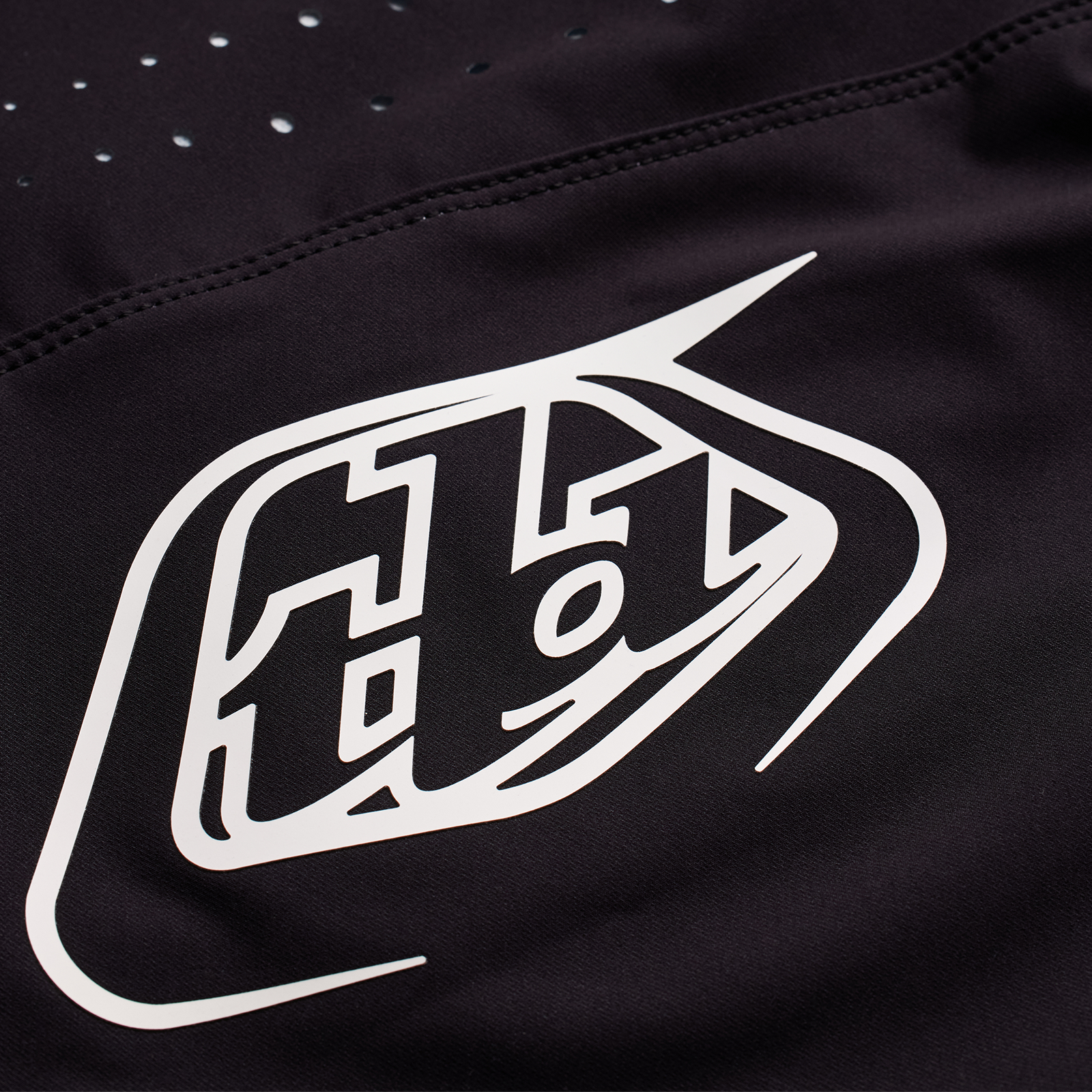 Close-up of a durable TLD Youth Sprint Pant Mono Black racing pant fabric with a stylized white TLD Sprint Pant logo.