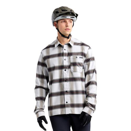 Wearing a TLD 24.2 Grind Flannel Shirt and gloves, they look aside with determination, their helmet hinting at an adventure. The quick-dry fabric ensures comfort as they gear up for the day ahead.