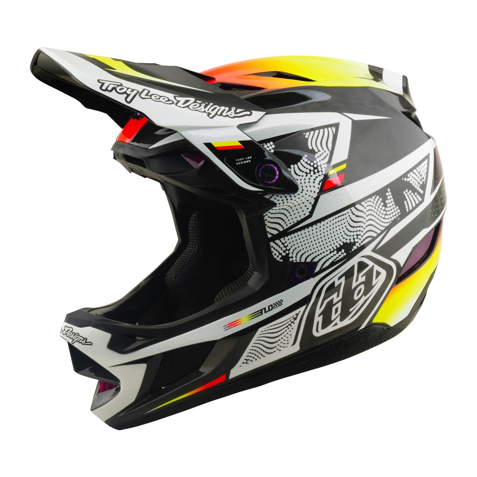 The TLD 26.1 D4 AS Carbon Helmet / Lined Up is a full-face helmet in black, white, and yellow with geometric graphics and "Troy Lee Designs" branding, featuring Mips protection and shown from the side.