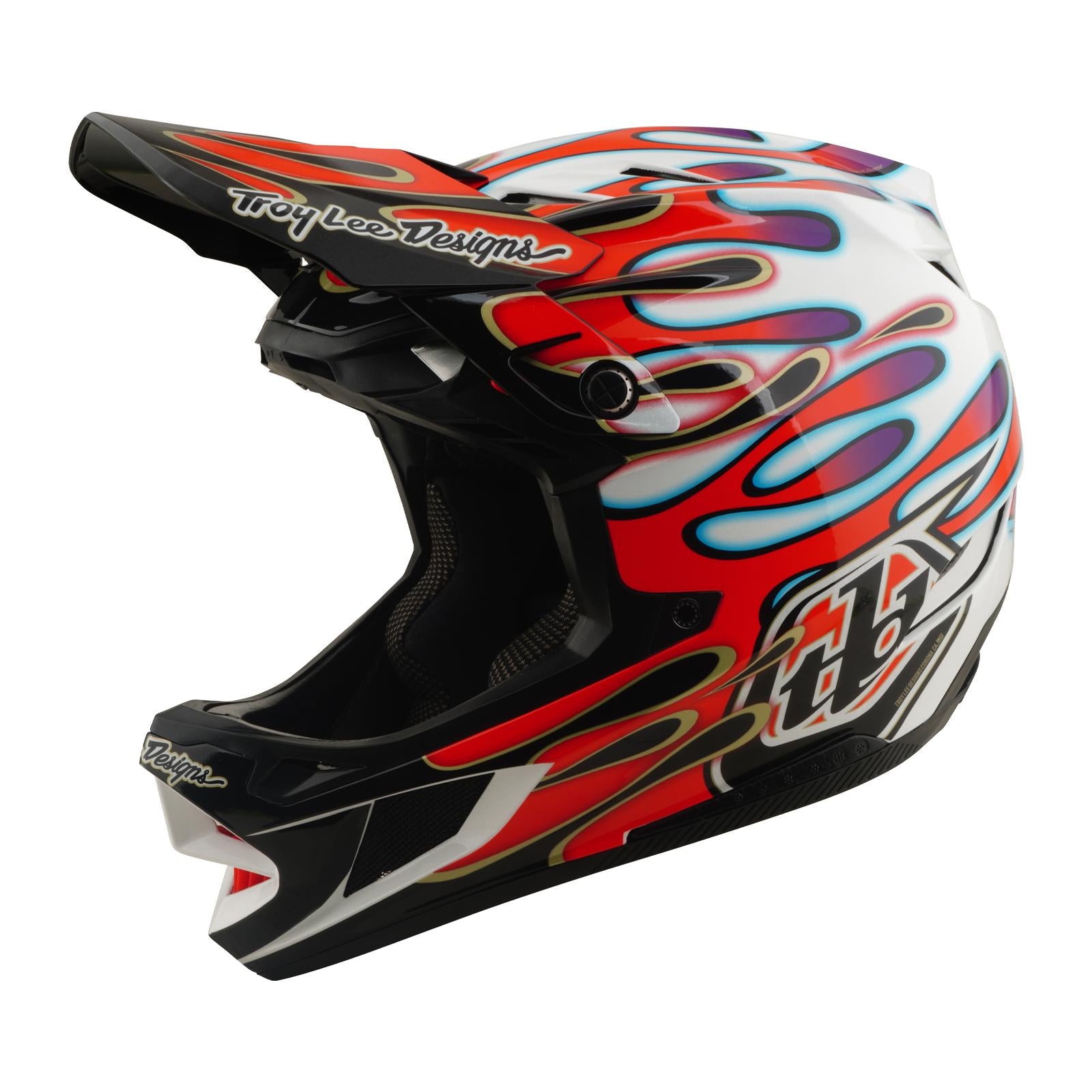 The TLD 26.1 D4 AS Composite Helmet in Overspray White/Red features a red, blue, and purple flame design, black visor, Troy Lee Designs branding on white, and Mips protection for enhanced safety.
