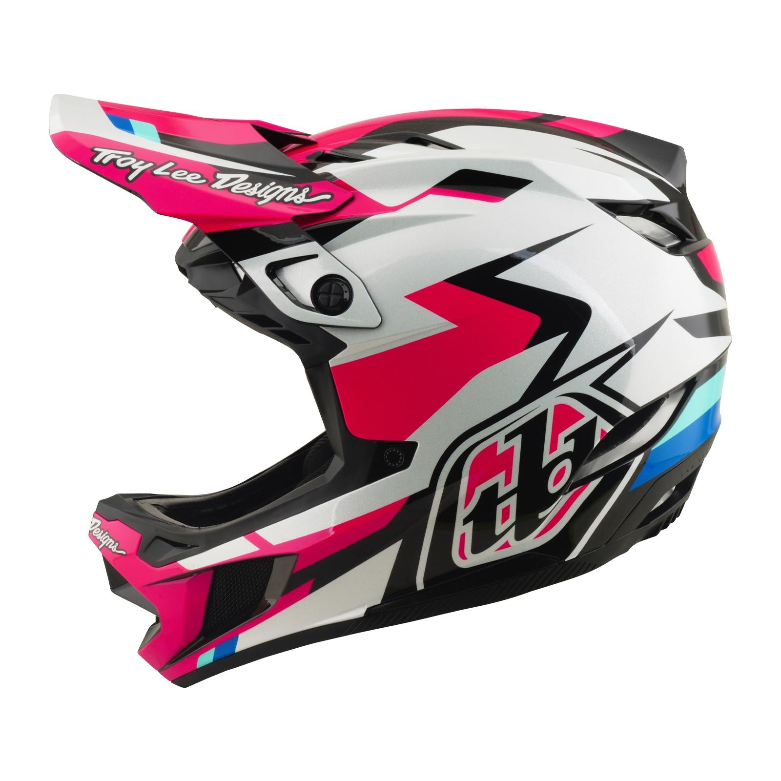 The TLD 26.1 D4 AS Polyacrylite Helmet / Roamer Magenta is a full-face helmet for motocross or mountain biking, featuring a pink, black, white, and blue geometric design, "Troy Lee Designs" logo on the visor, and Mips brain protection.