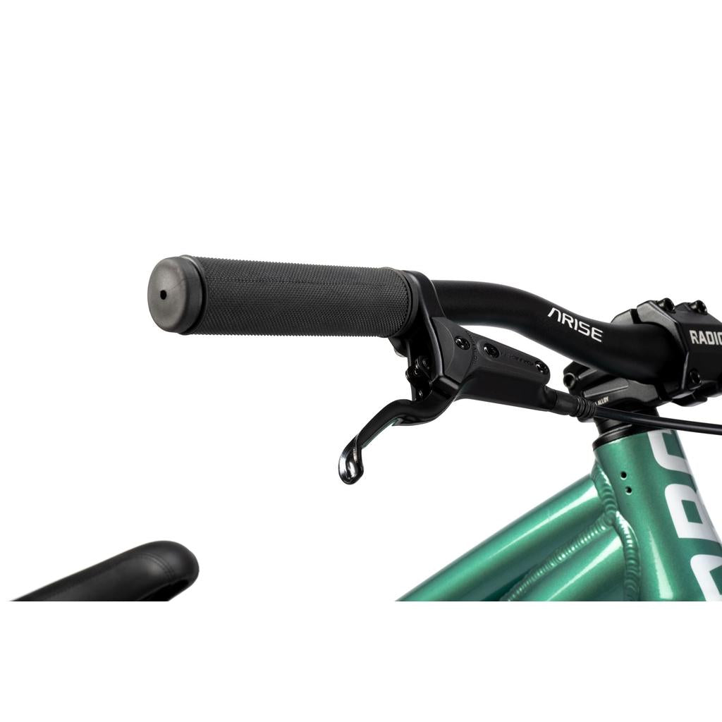 Close-up of the Radio Griffin 24 Inch Dirt Jumper Bike's right handlebar grip, brake lever, and part of its metallic green frame.