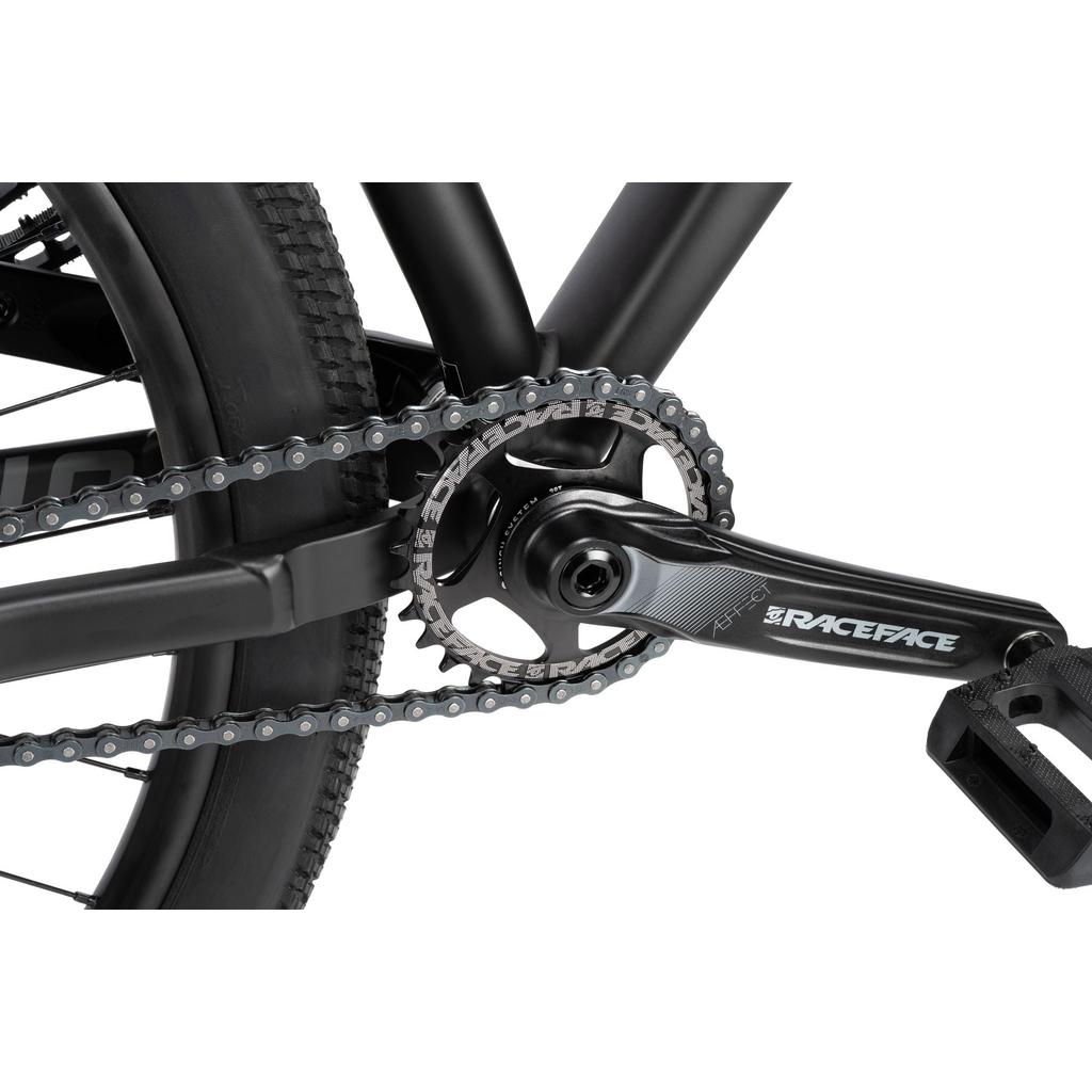 Close-up of the drivetrain on a Radio 26 Inch Griffin Pro Bike with an alloy frame, featuring a Race Face crankset, chainring, and chain; rear tire and pedal are partially visible.