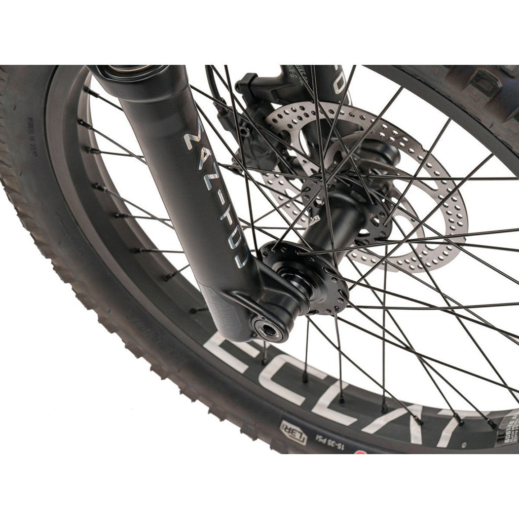 A close up of the front wheel of a mountain bike, specifically a full-suspension Wethepeople Swampmaster 20 Inch Bike.